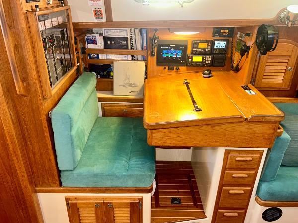 Navigation station in 1999 Pacific Seacraft 40 Voyagemaker with wood finish and teal cushions.