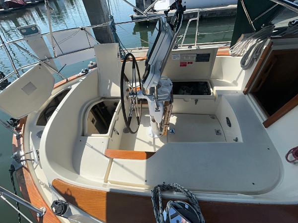 1999 Pacific Seacraft 40 Voyagemaker sailboat cockpit with steering wheel and navigation equipment.