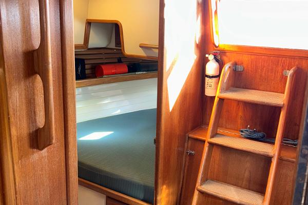 Interior of 1999 Pacific Seacraft 40 Voyagemaker, featuring wooden ladder and cozy sleeping area.