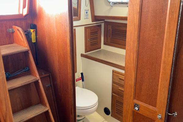 Interior of 1999 Pacific Seacraft 40 Voyagemaker yacht bathroom with wooden cabinetry.