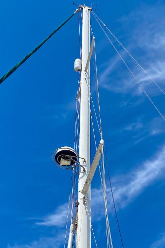 Mast of 1999 Pacific Seacraft 40 Voyagemaker sailboat against clear blue sky.
