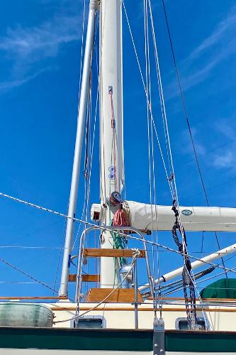 Sailboat mast and rigging of 1999 Pacific Seacraft 40 Voyagemaker against blue sky.
