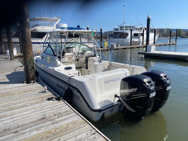 2005 Boston Whaler 275 Conquest docked with twin Mercury engines.
