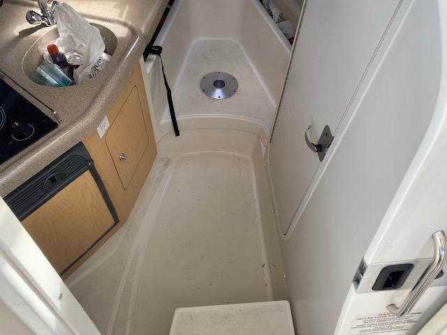 Interior of 2005 Boston Whaler 275 Conquest boat, featuring compact kitchenette and storage.