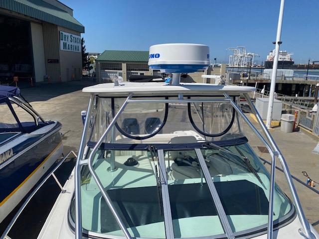 2005 Boston Whaler 275 Conquest at marina, featuring radar equipment and dockside view.
