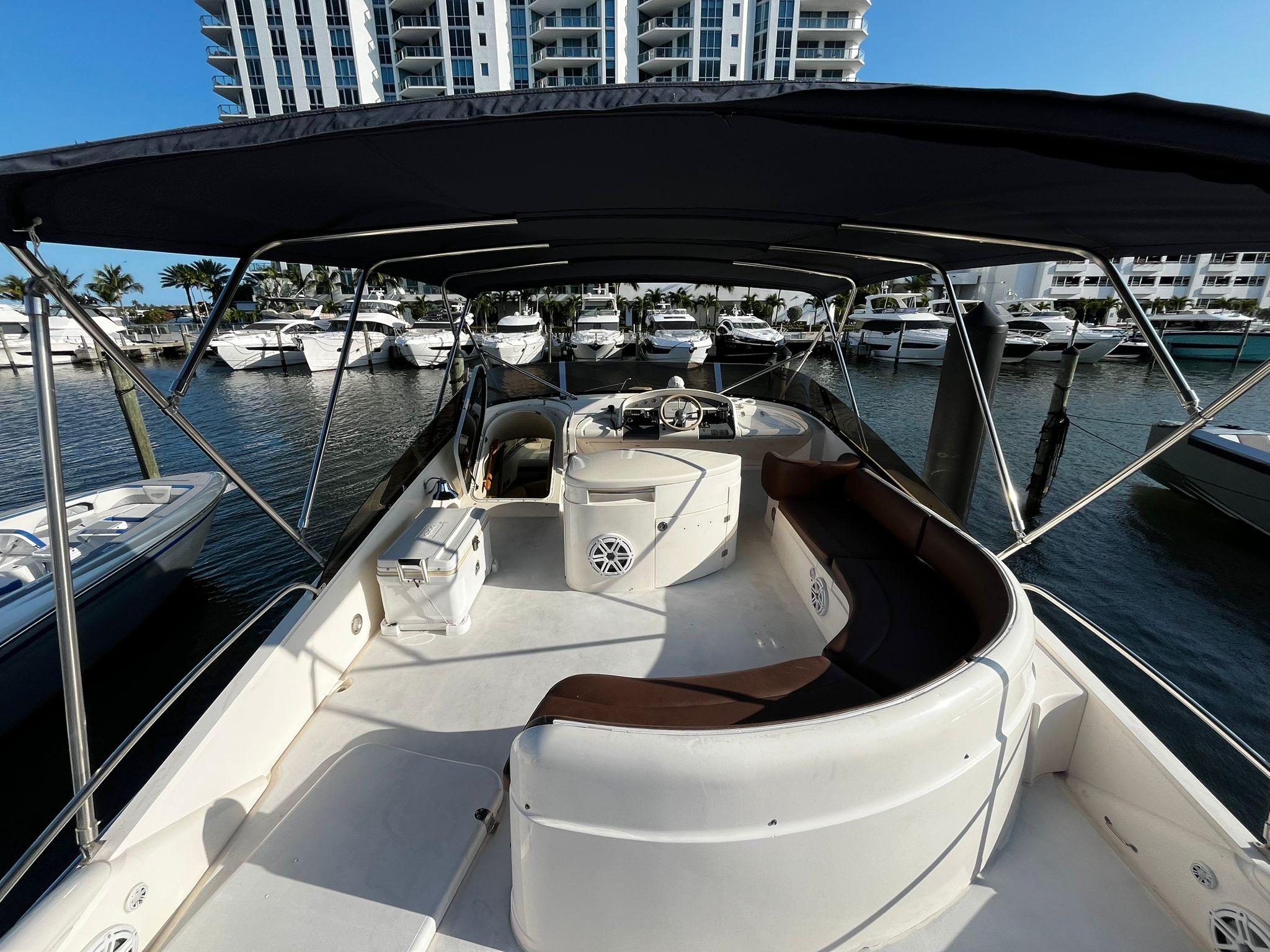 Fairline-Squadron 55 2001 -FL-US-2001 Fairline Squadron 55 yacht interior with seating, docked in marina, modern buildings in background.-9778674 | Thumbnail