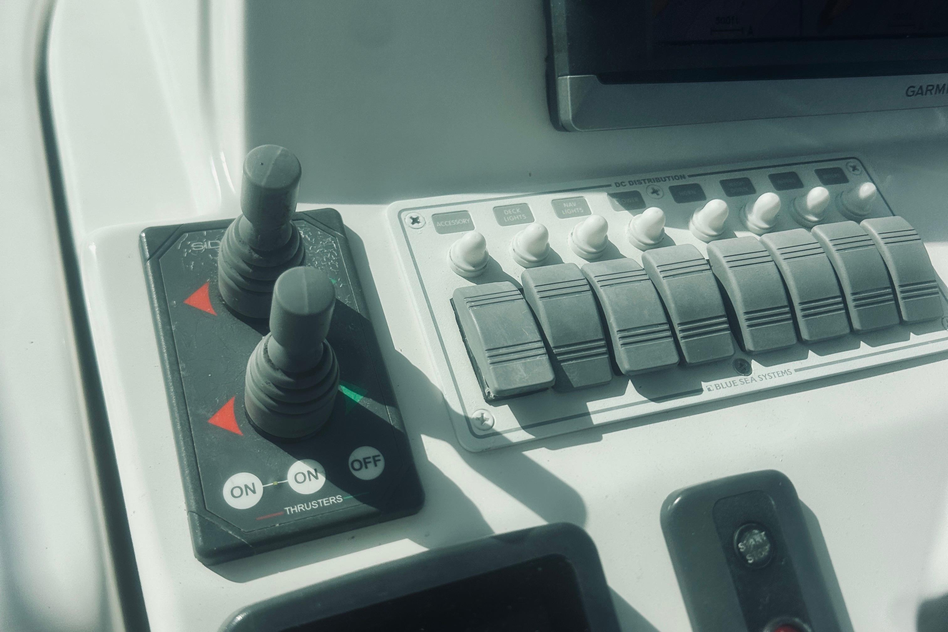Control panel of a 2013 Back Cove 30 boat with switches and thruster controls.