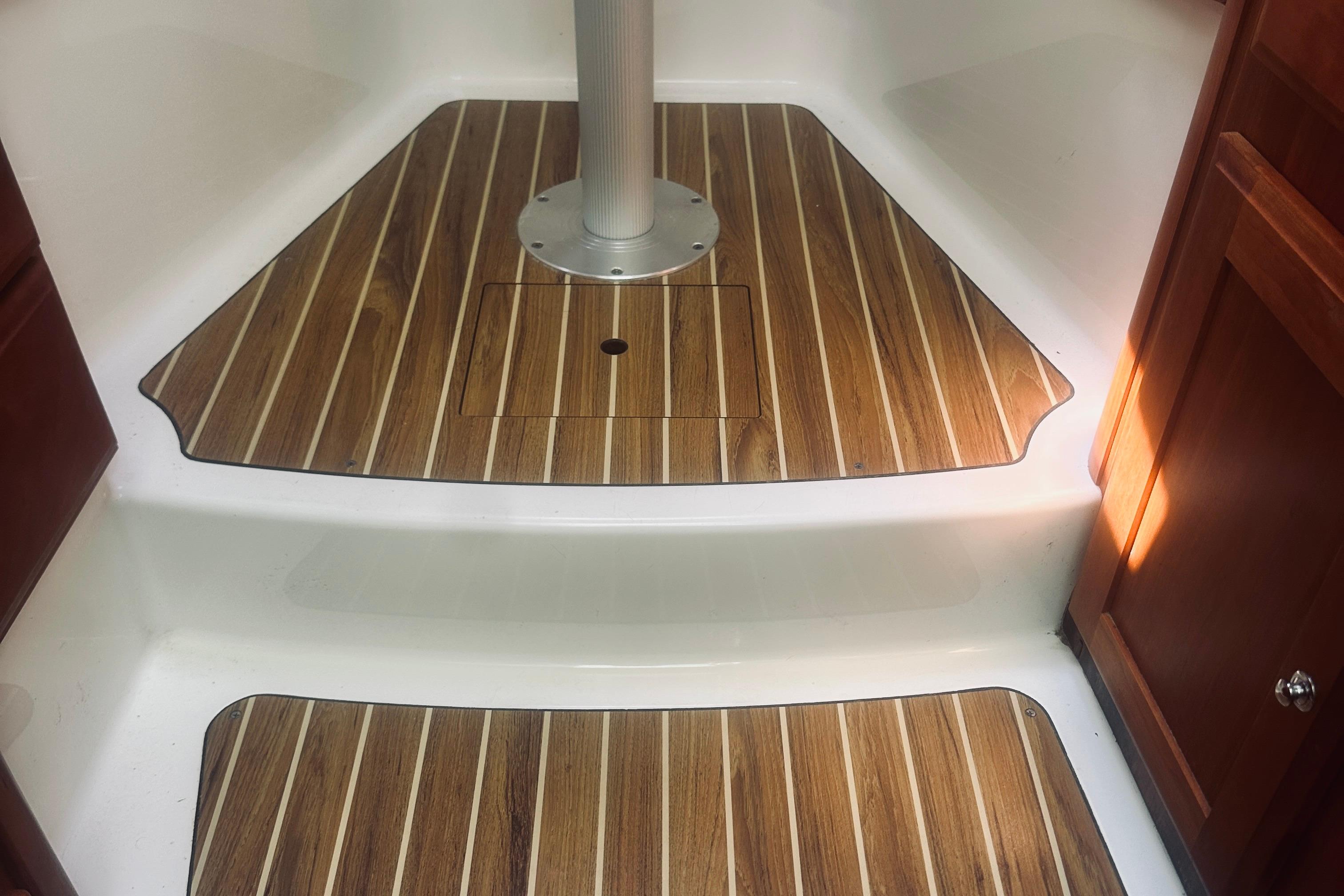 2013 Back Cove 30 boat interior with wood-patterned flooring and white steps.