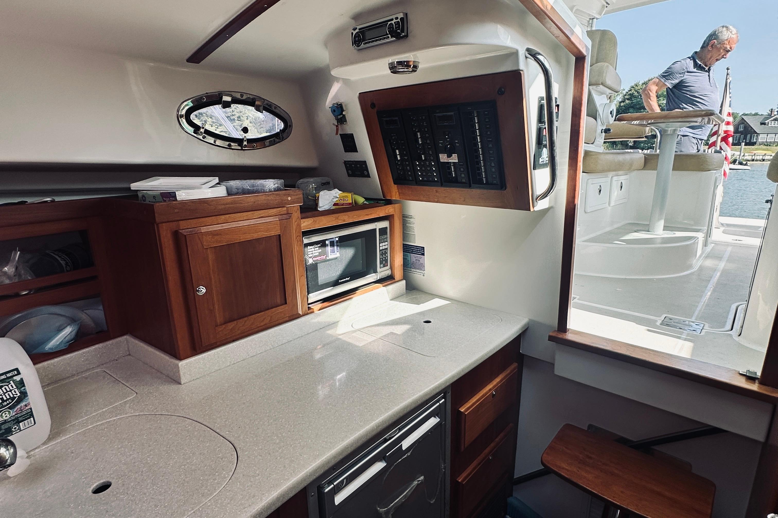 Interior of 2013 Back Cove 30 boat with kitchenette and control panel.