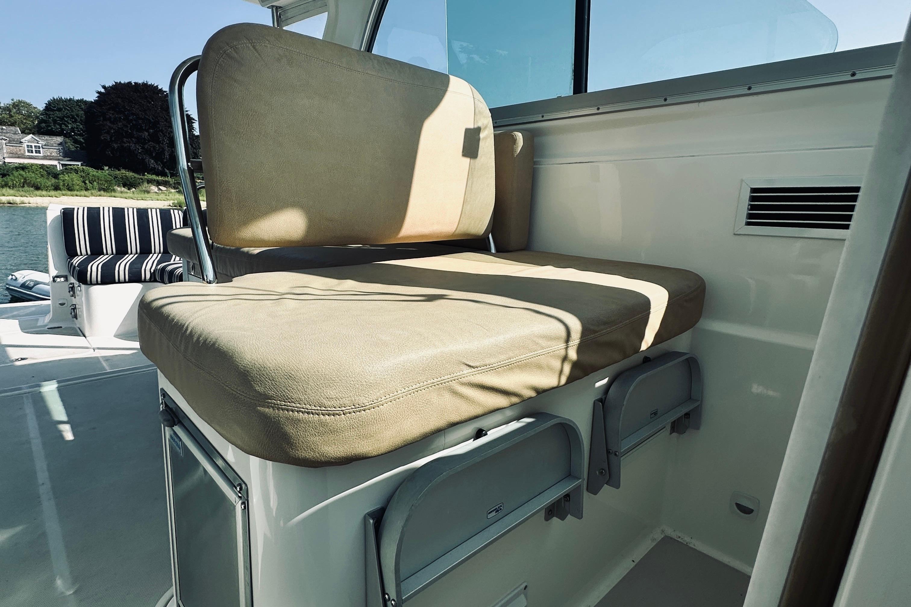 2013 Back Cove 30 boat interior with beige cushioned seating and storage compartments.