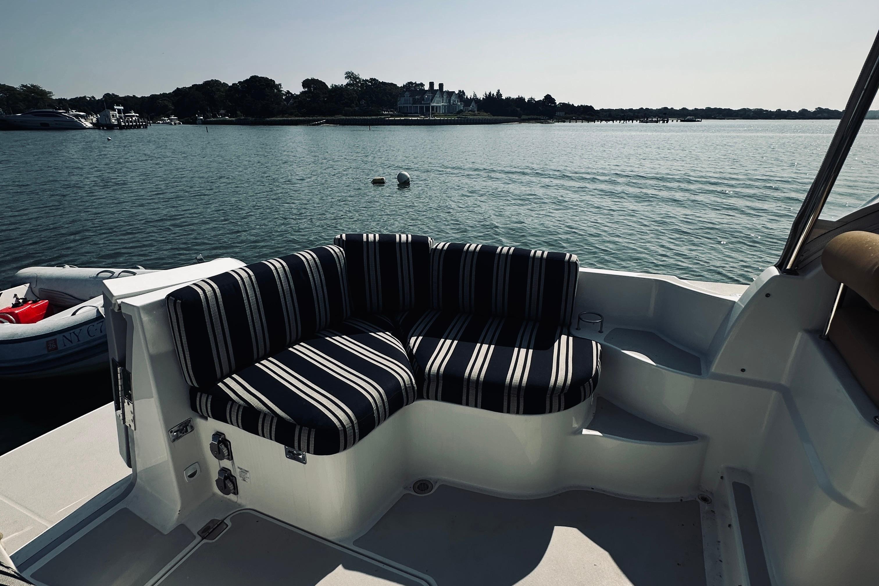 2013 Back Cove 30 boat with striped seating, overlooking calm waters and distant shoreline.