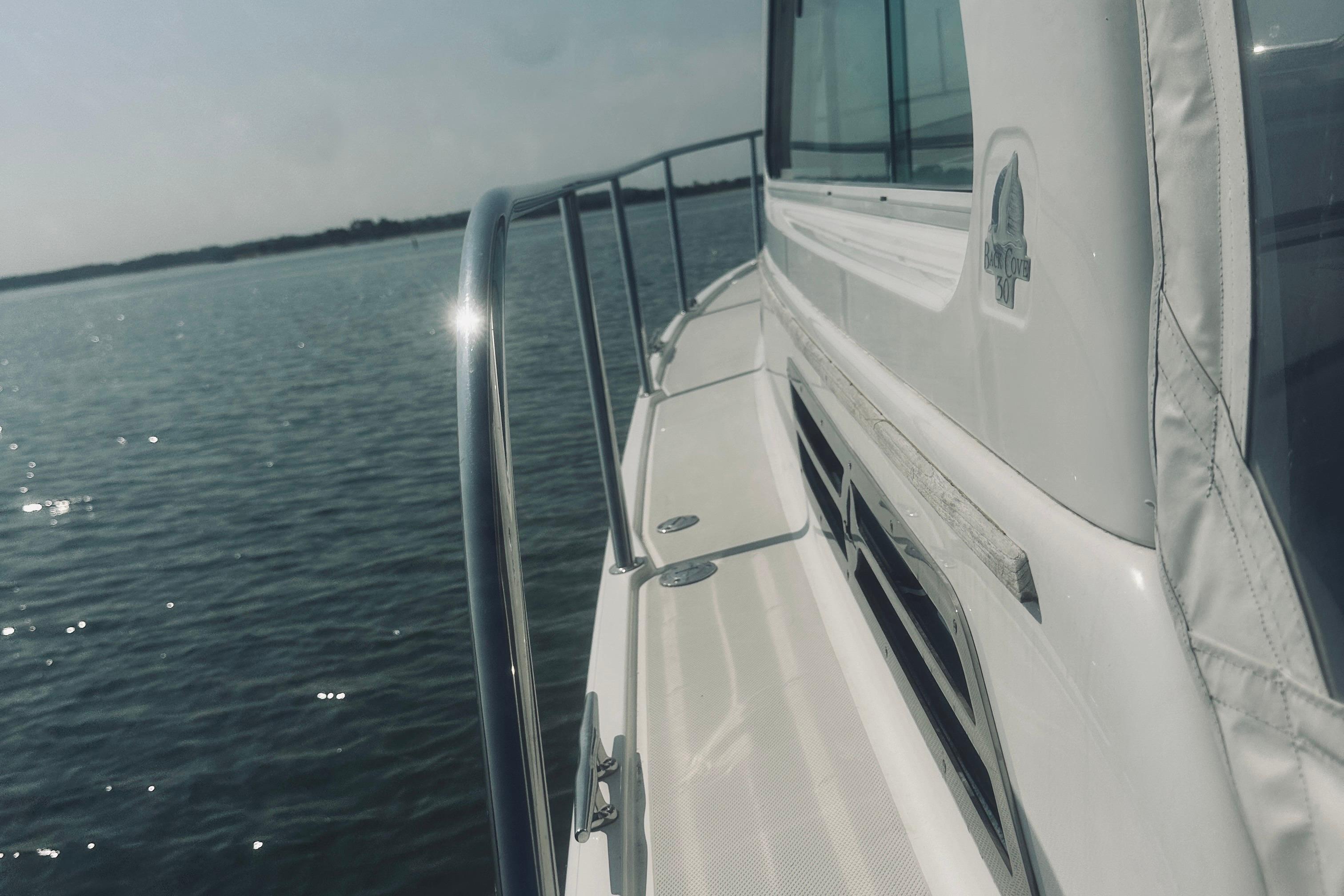 2013 Back Cove 30 boat on calm water, showcasing sleek design and railing.
