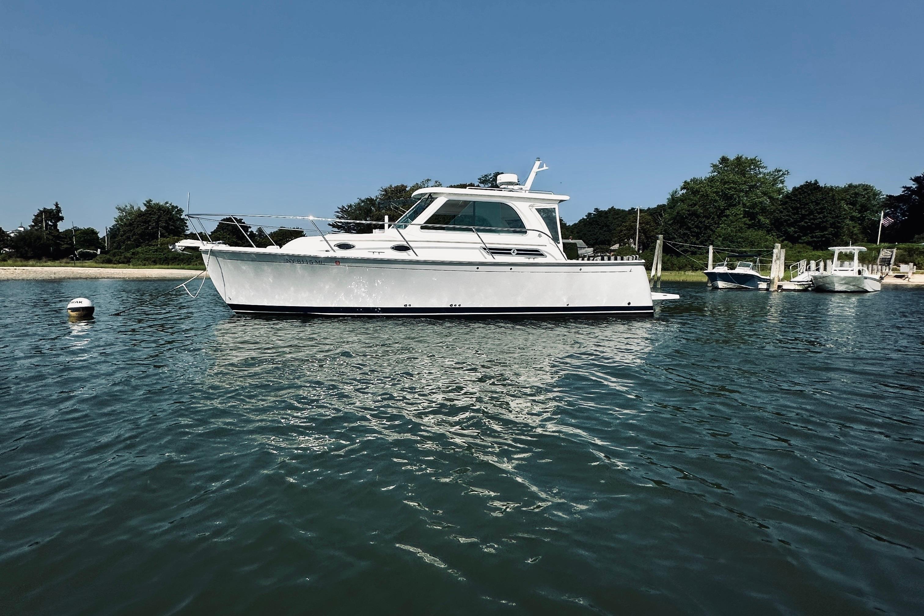 2013 Back Cove 30 boat anchored in calm waters near a shoreline.