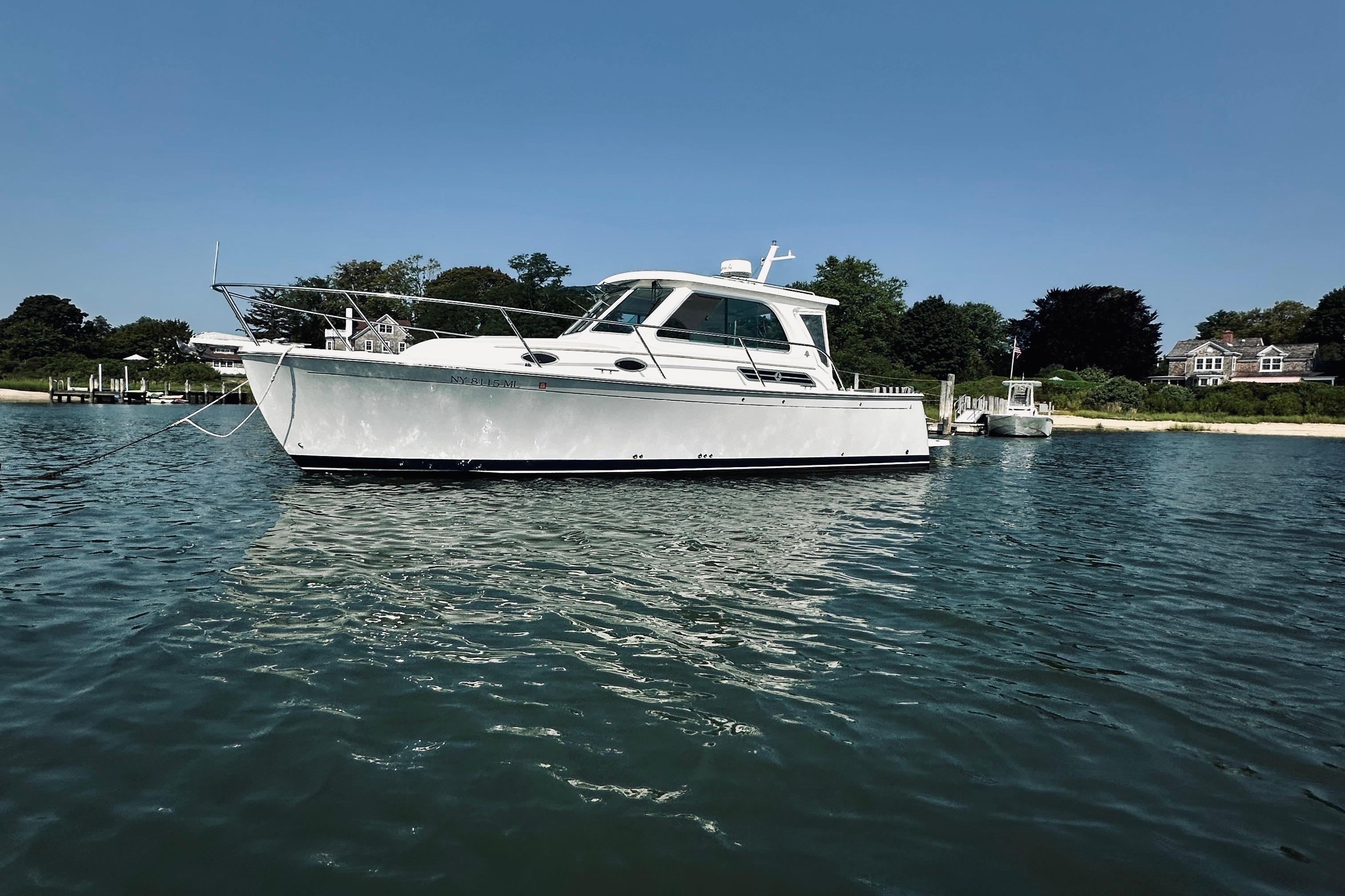 2013 Back Cove 30 boat anchored in calm waters near a shoreline.