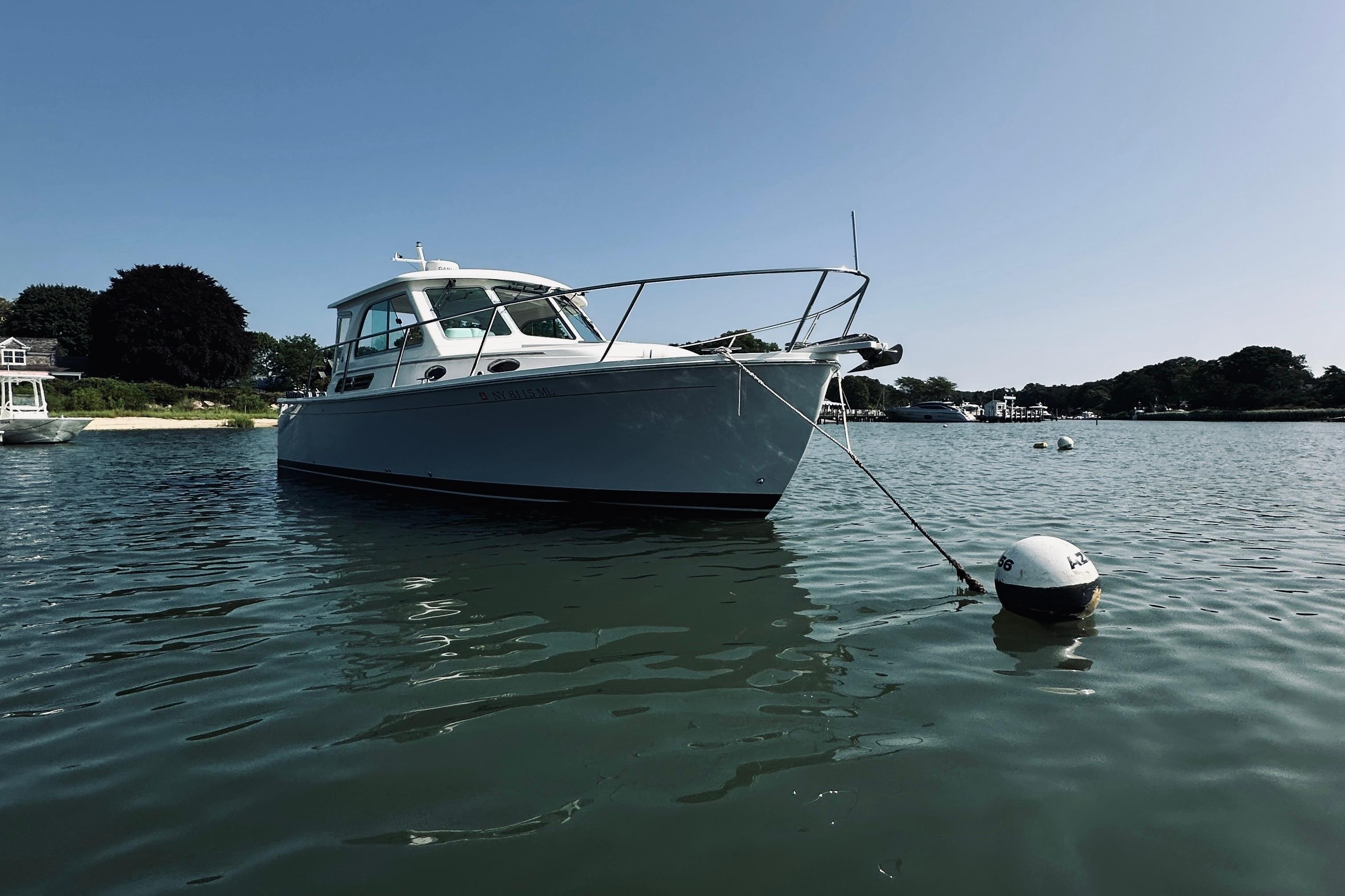 2013 Back Cove 30 boat moored in calm waters on a sunny day.