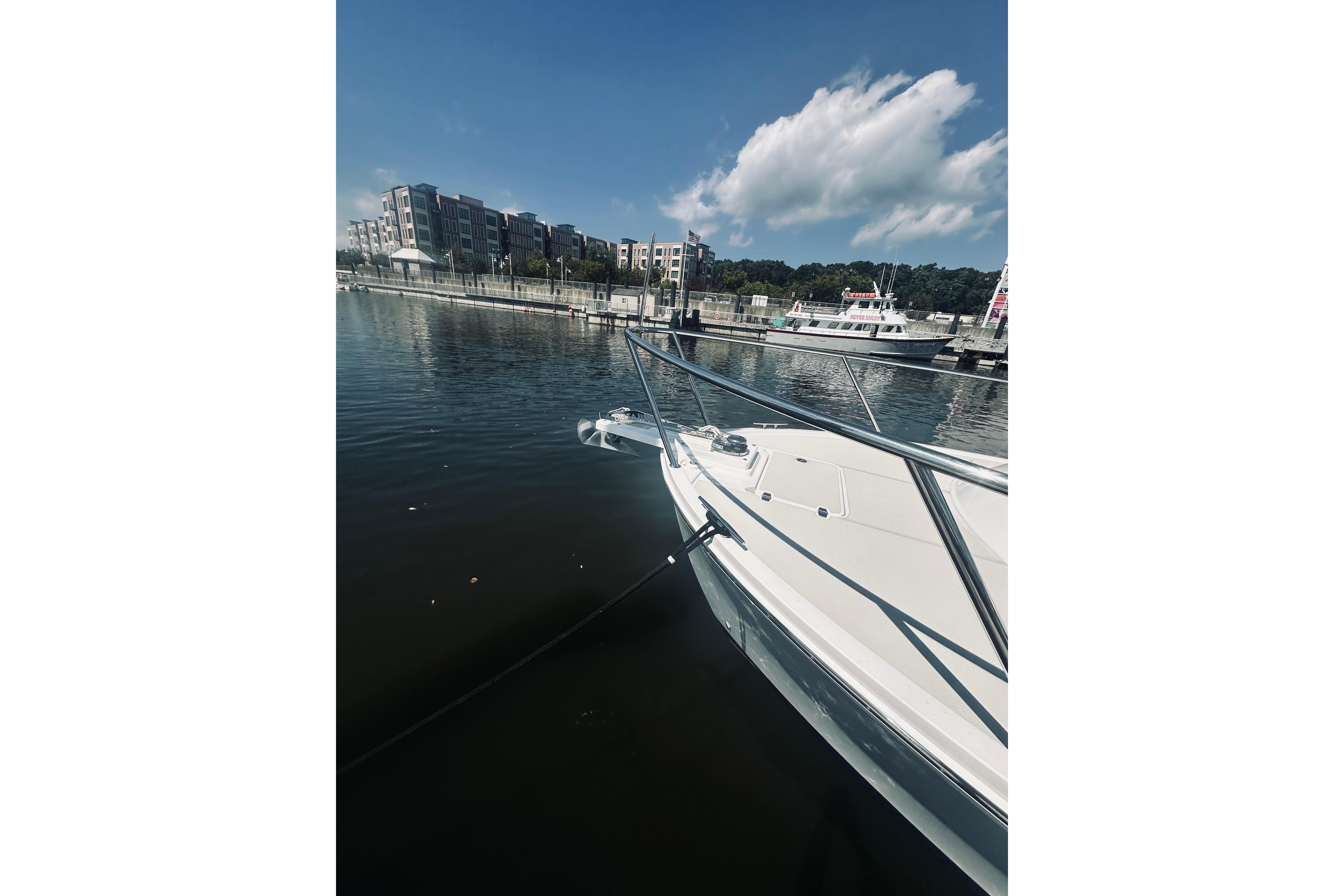 2013 Back Cove 30 boat docked in a marina with buildings in the background.