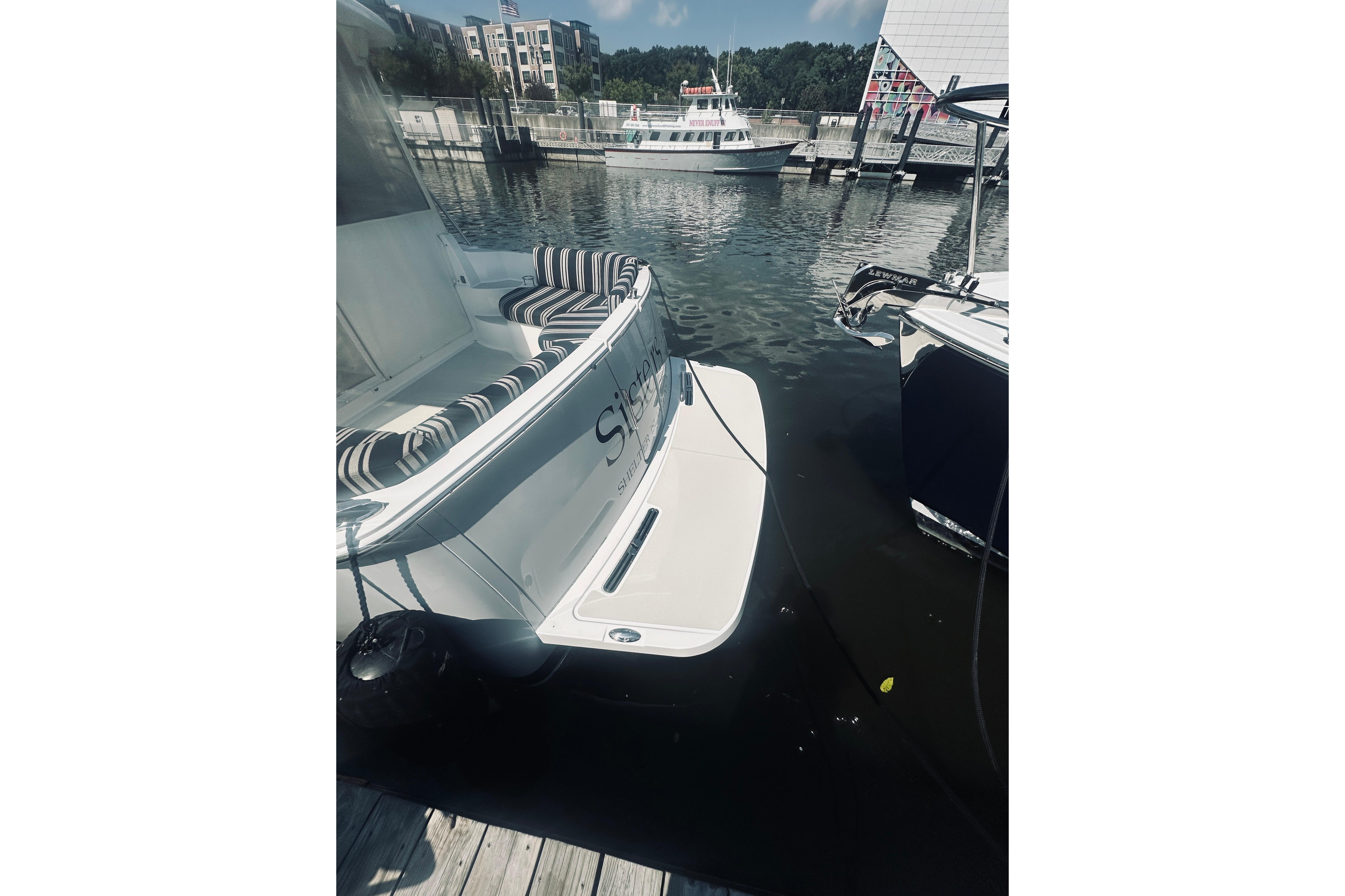 2013 Back Cove 30 boat docked at marina with striped seating.