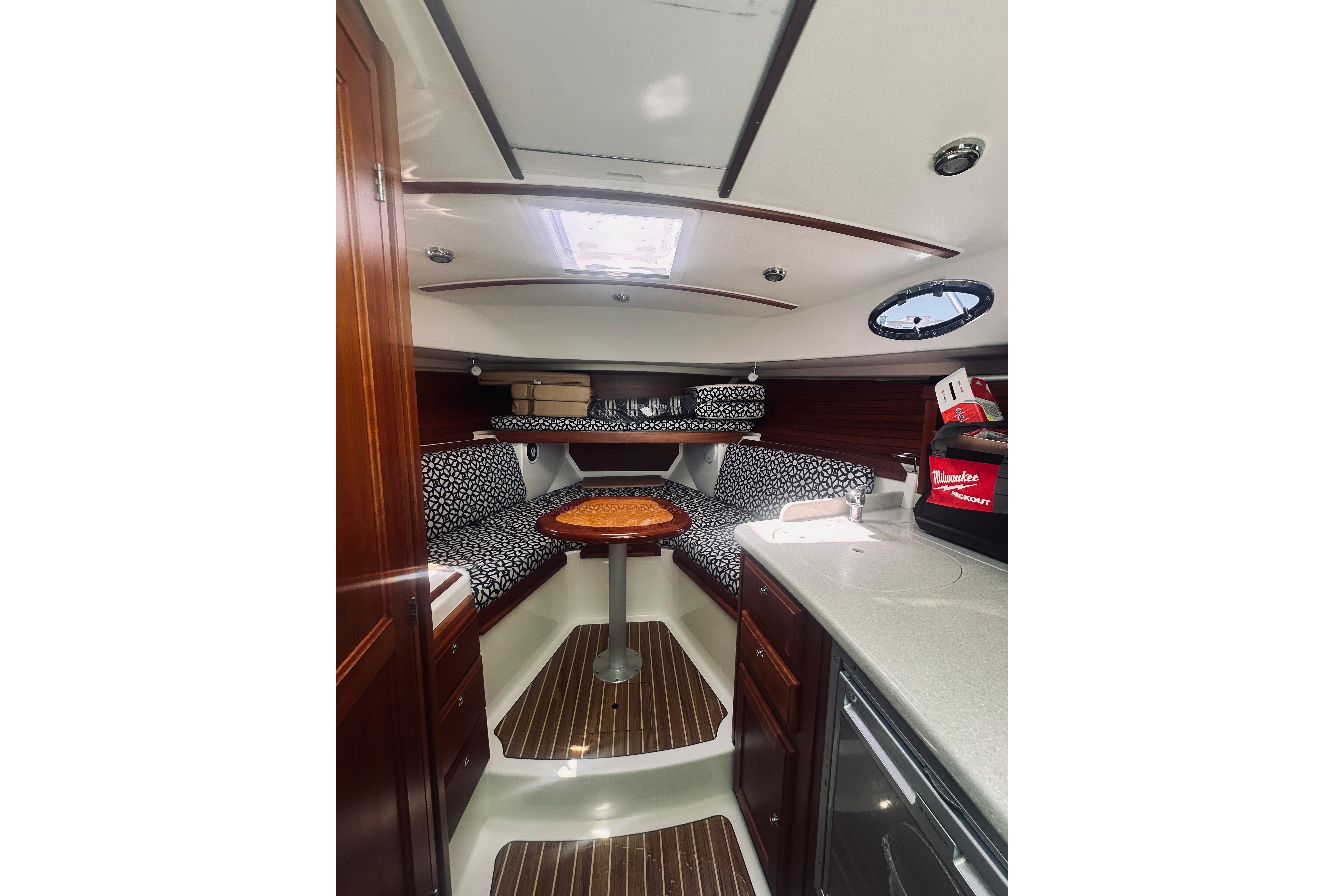 2013 Back Cove 30 interior with wood accents, patterned seating, and compact kitchenette.