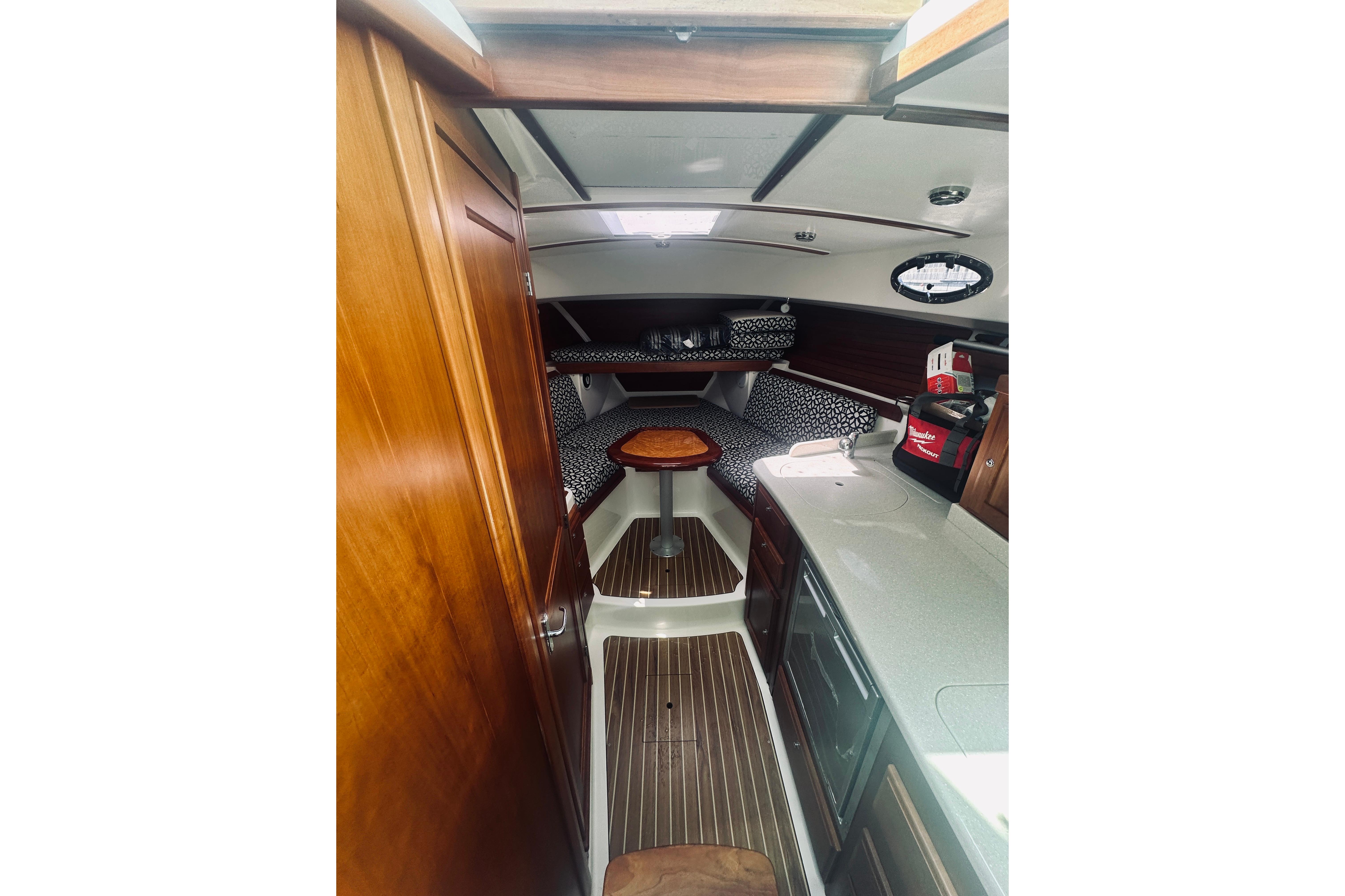 2013 Back Cove 30 boat interior with wood finish, compact kitchen, and cozy seating area.