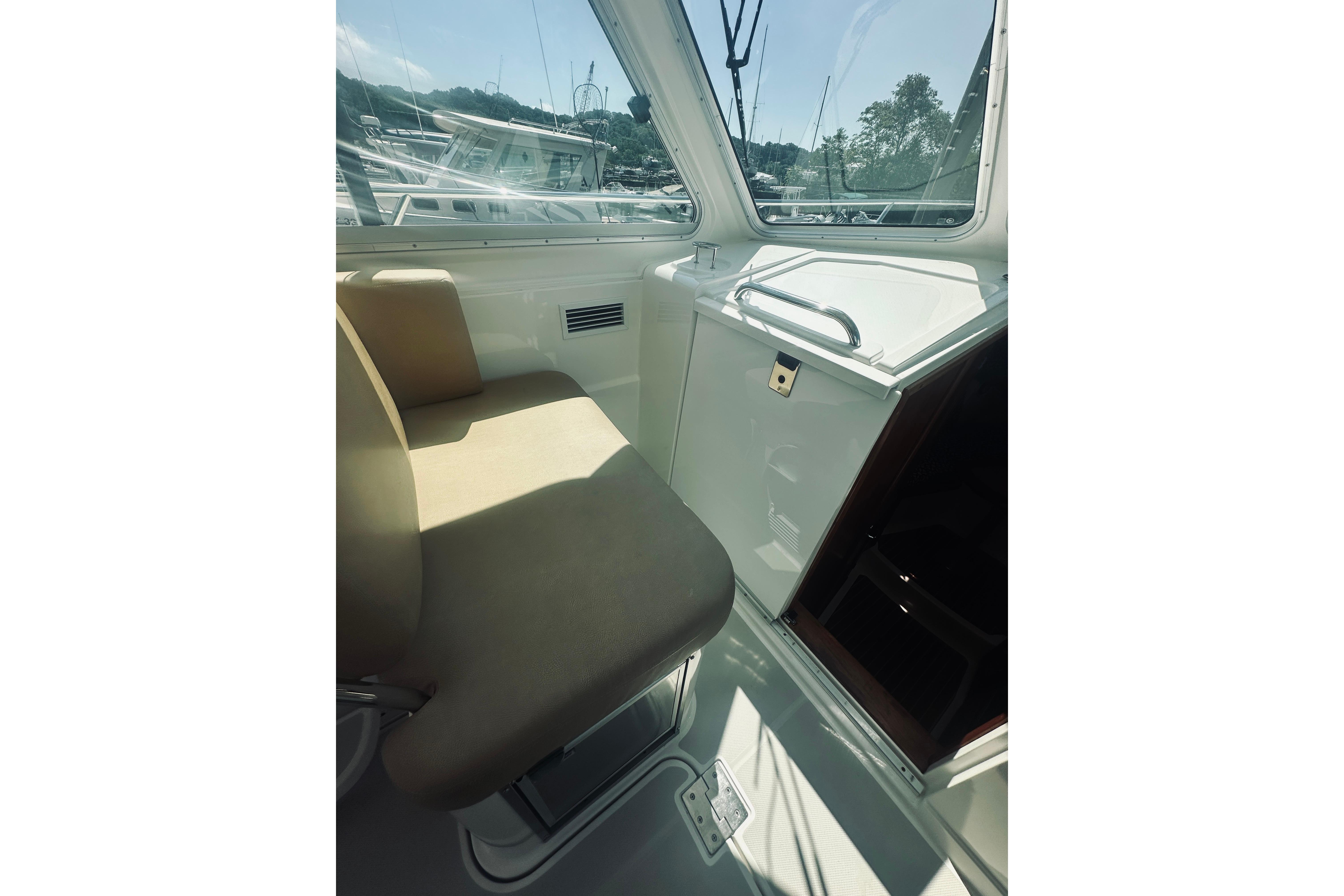 Interior of 2013 Back Cove 30 boat with beige seating and window view.
