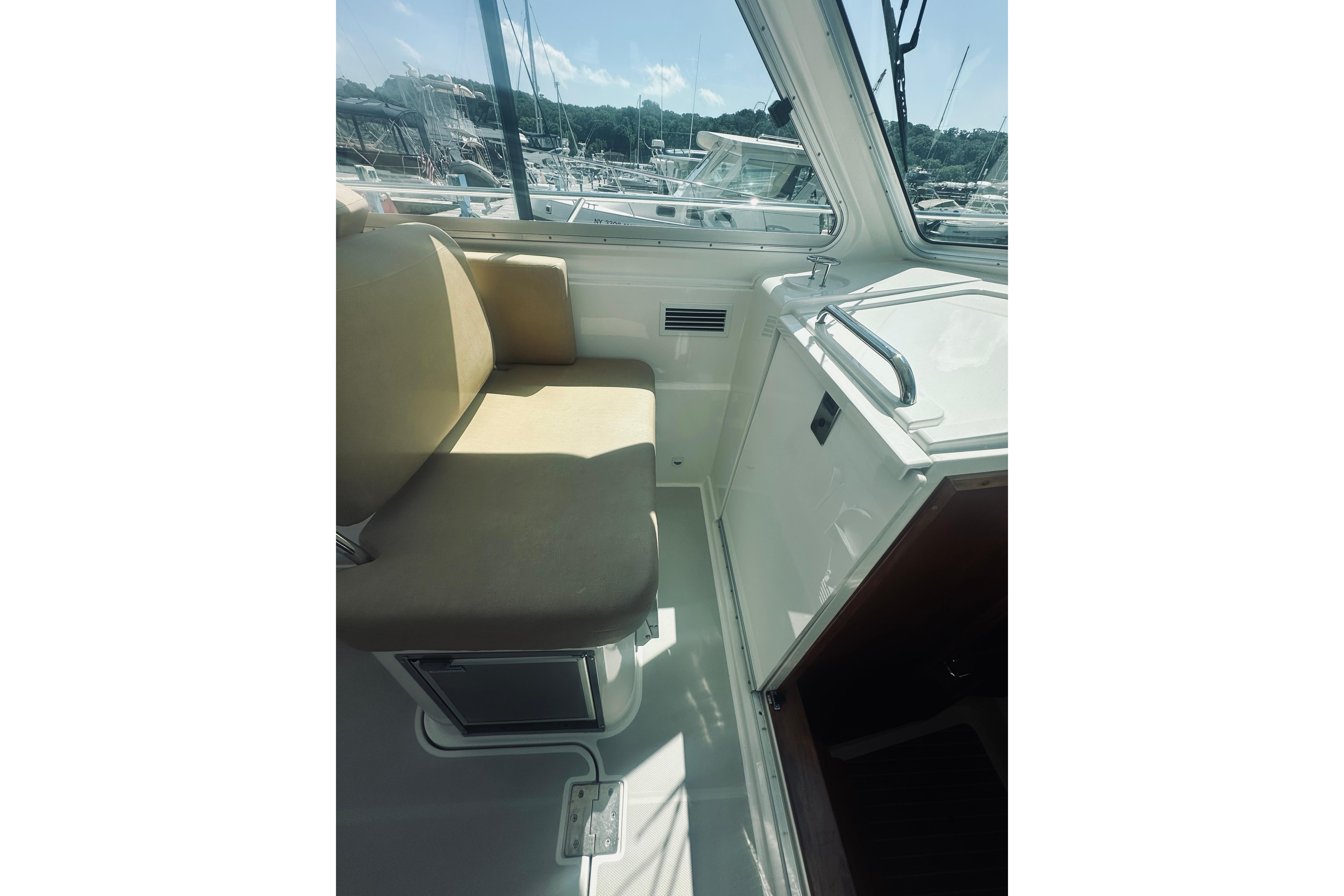 Interior of 2013 Back Cove 30 boat with beige seating and window view.