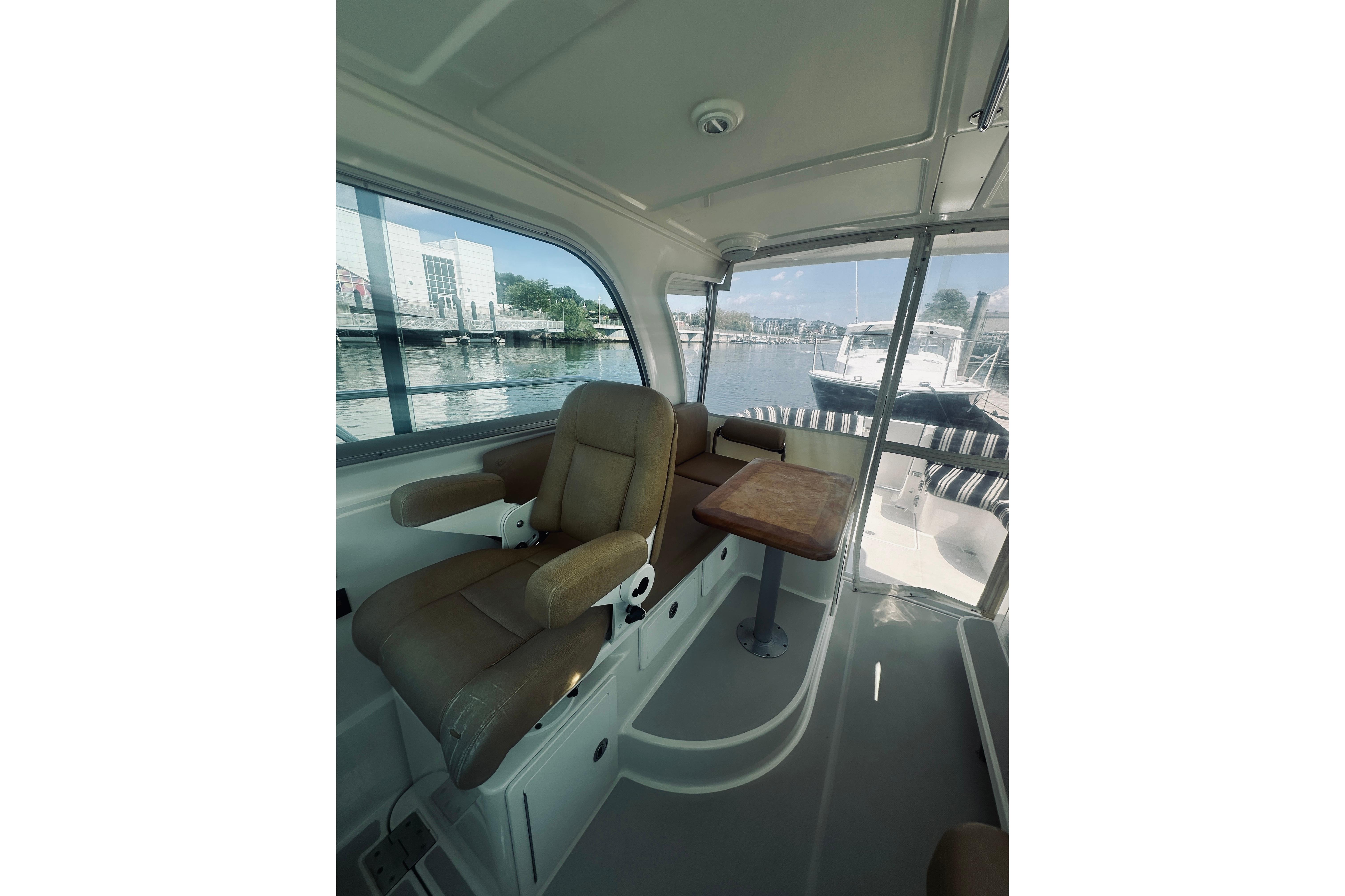 2013 Back Cove 30 interior with leather seating and wooden table, dockside view.