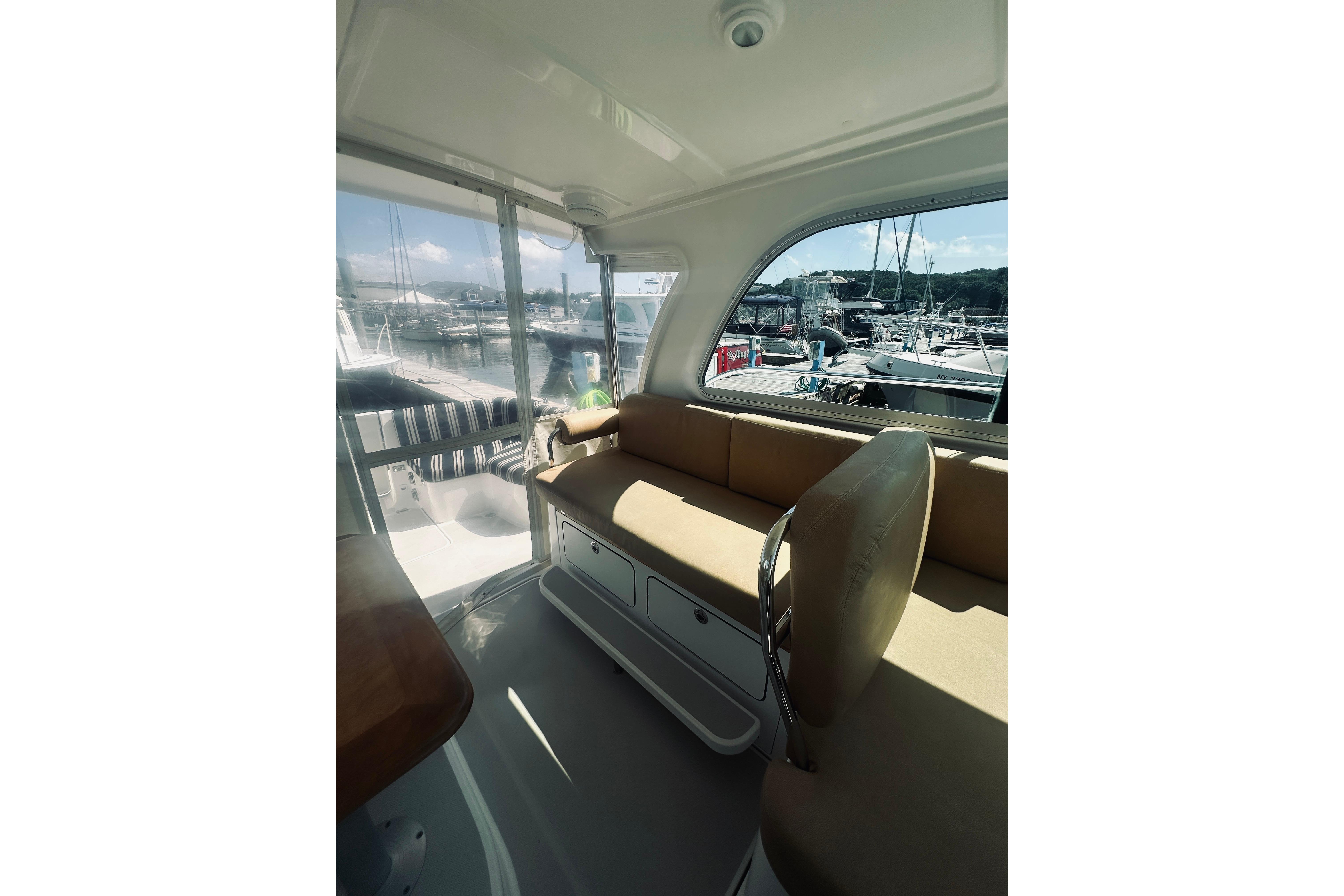 Interior of 2013 Back Cove 30 yacht with beige seating and marina view.