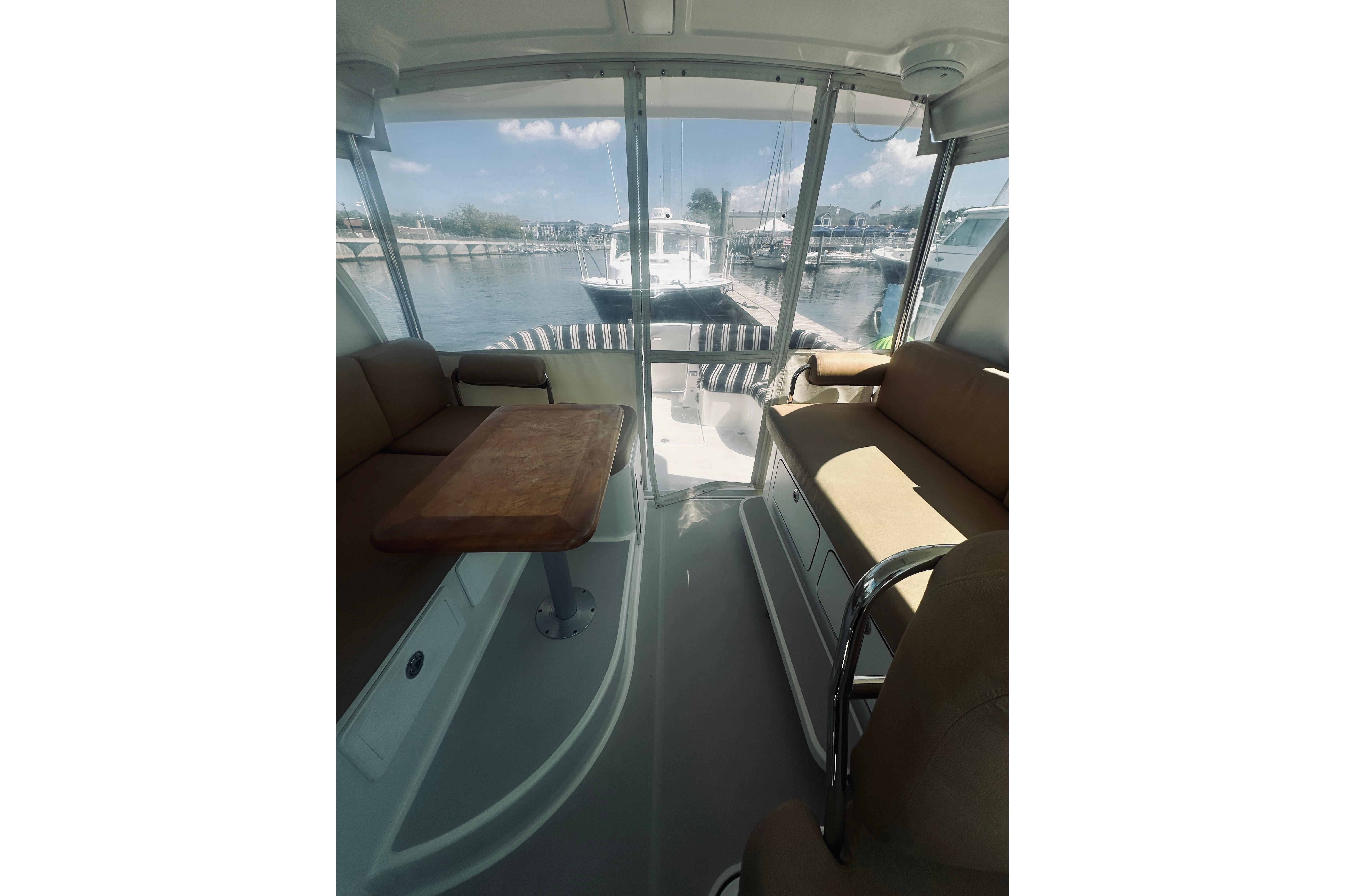 Interior view of 2013 Back Cove 30 boat with seating and table, docked at marina.