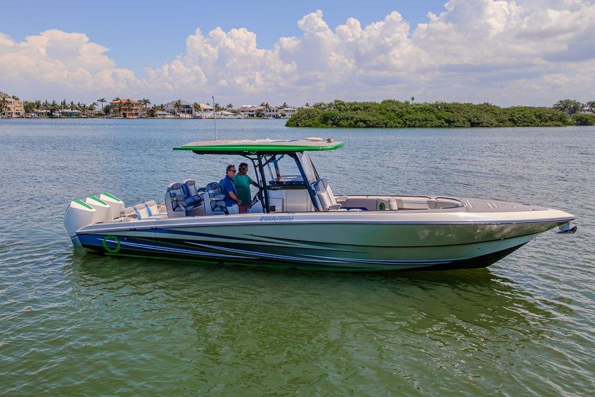 2022 Fountain 34 SC boat on calm water with two people onboard, scenic background.