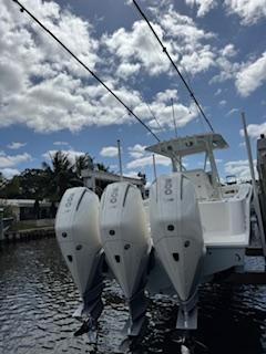 SeaVee-340Z 2024-REEL CRAFT FL-US-2024 SeaVee 340Z boat with triple outboard engines, docked under a partly cloudy sky.-9768819 | Thumbnail