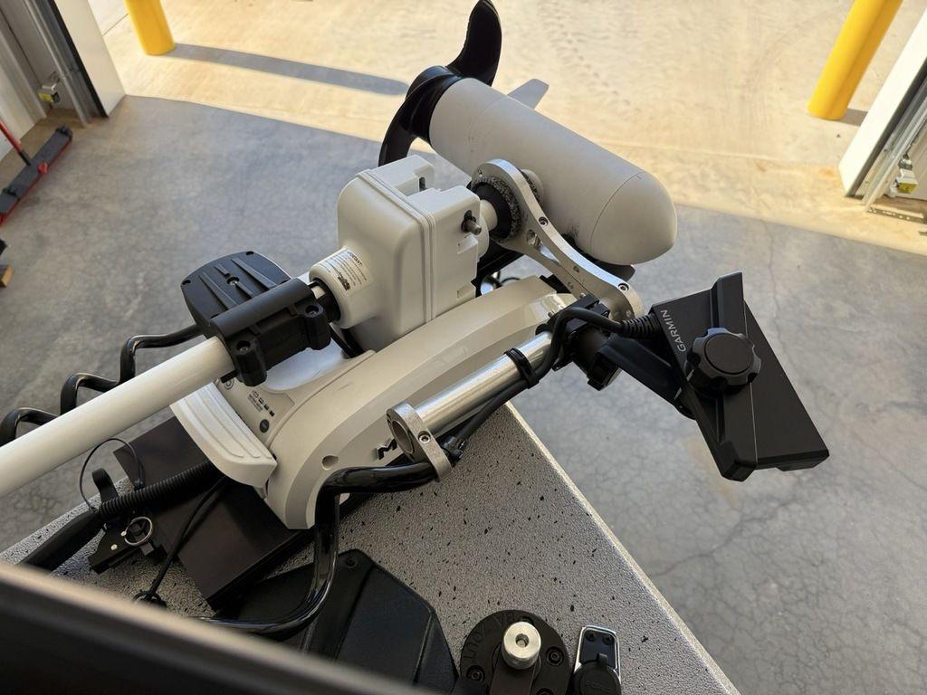 2024 Xpress H22B boat motor and control panel in a garage setting.