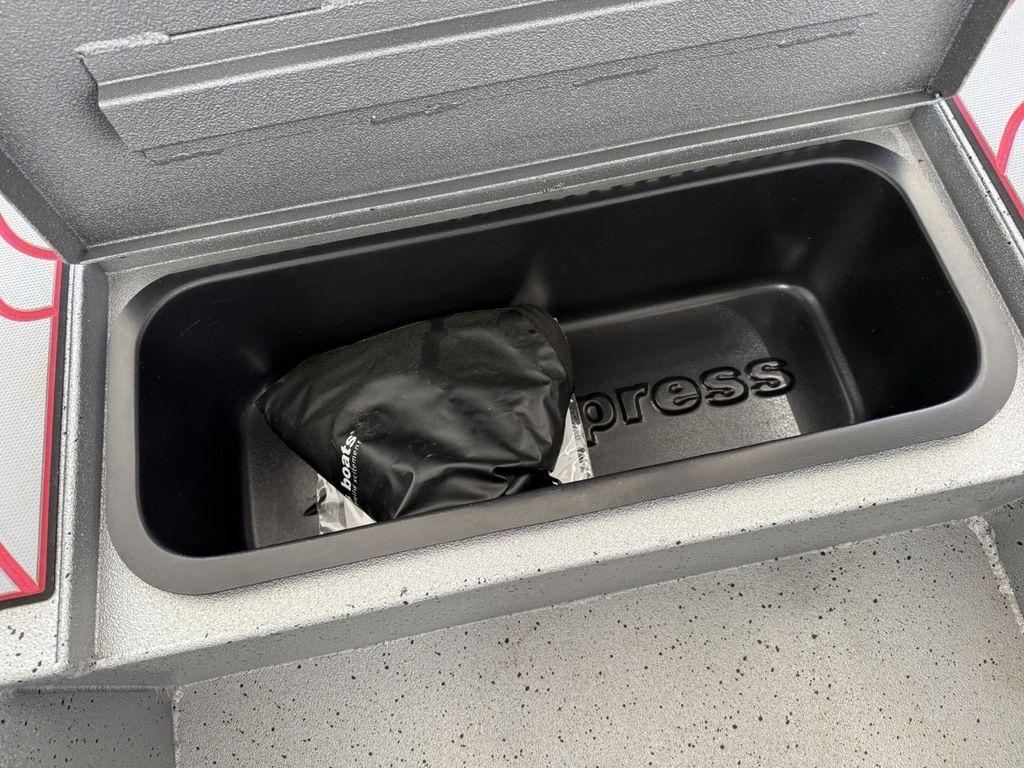 Storage compartment of 2024 Xpress H22B boat with a black cover inside.