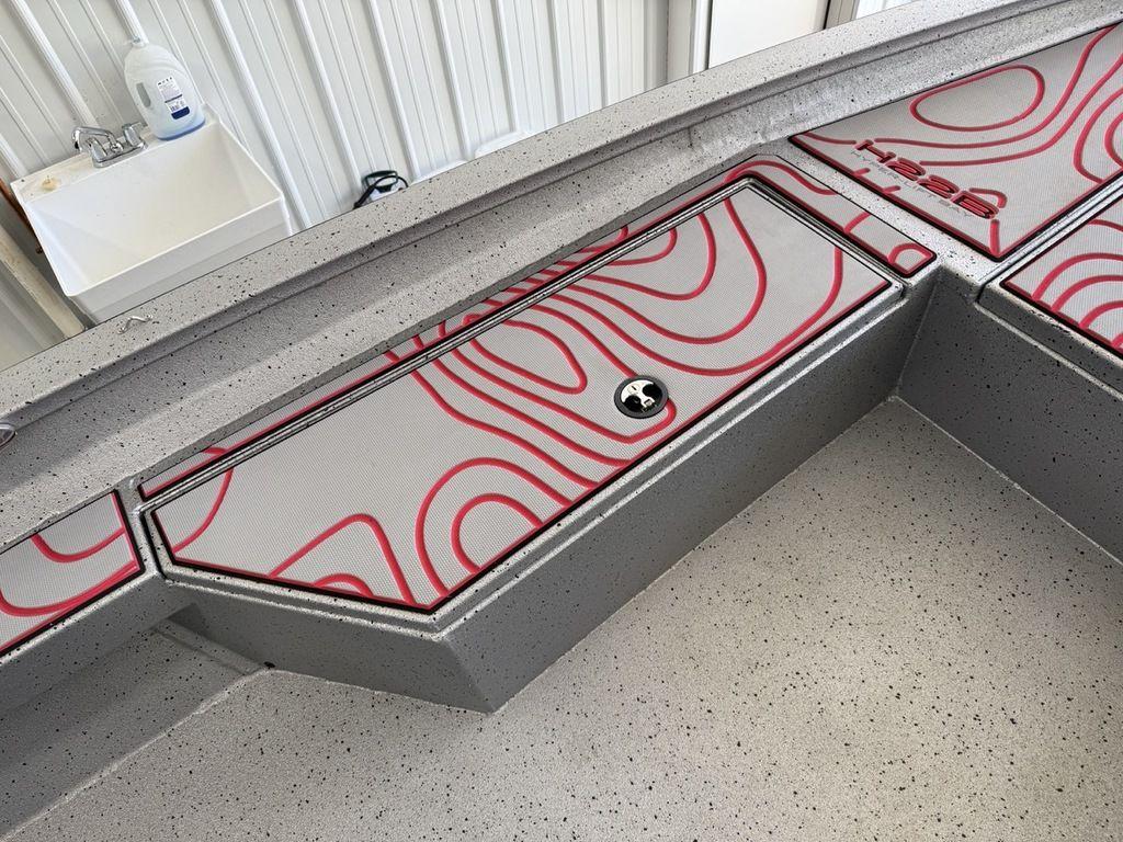 2024 Xpress H22B boat interior with red-patterned storage compartments.