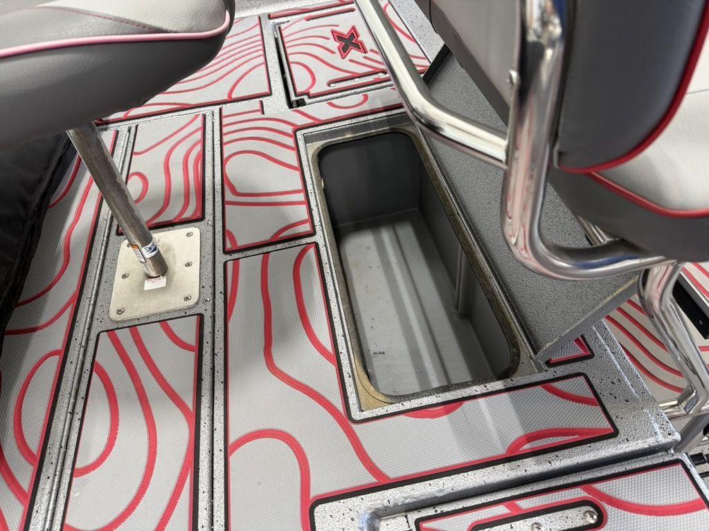 2024 Xpress H22B boat interior with storage compartment and stylish red-patterned flooring.