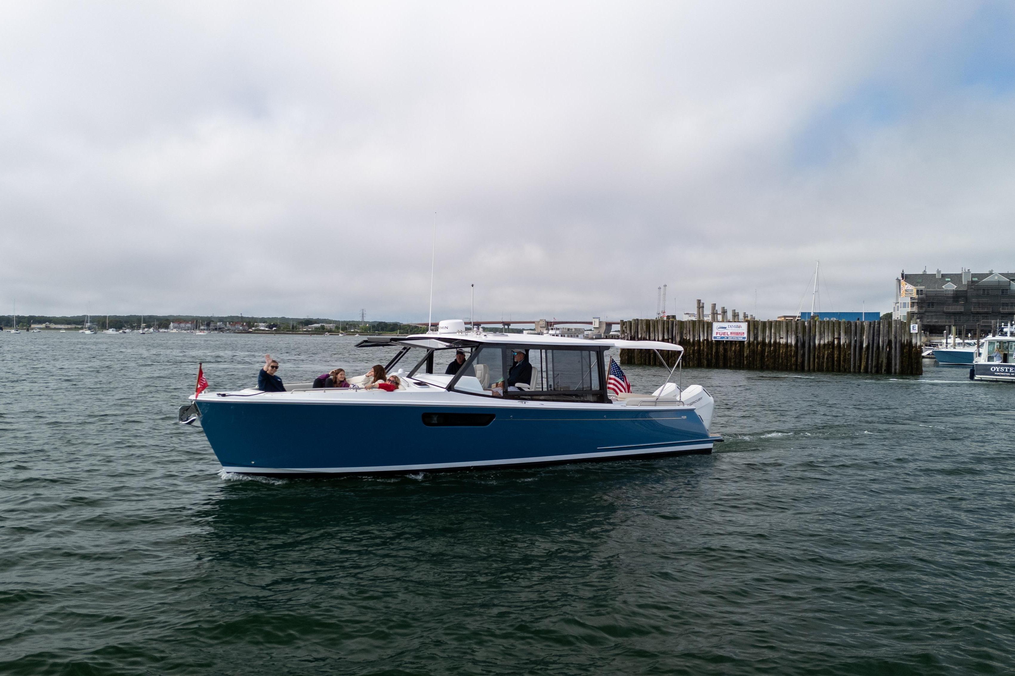 2025 MJM 3 boat cruising in a harbor with passengers on board.