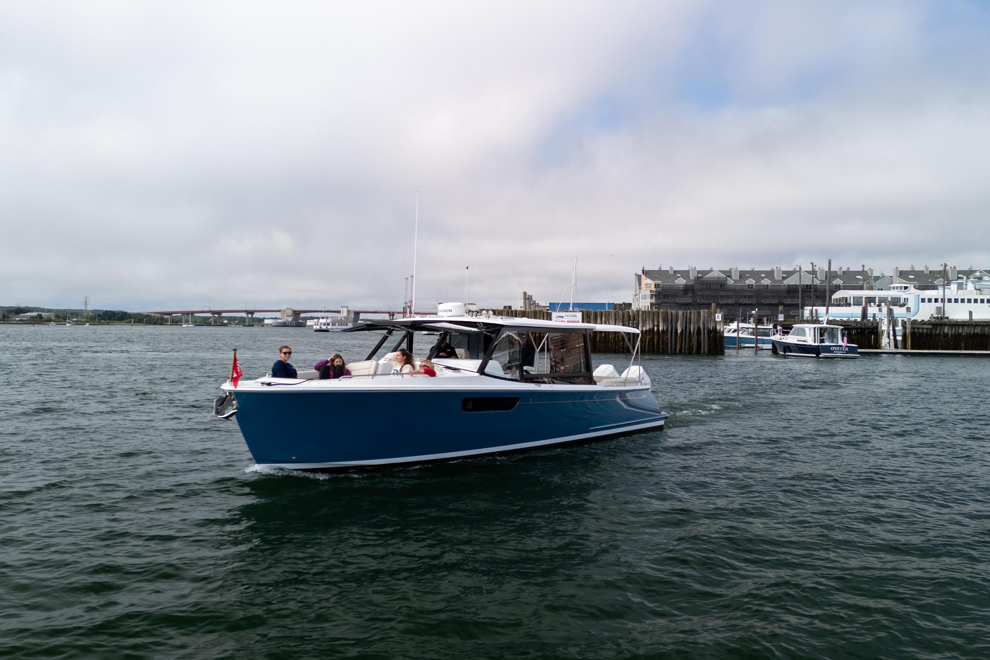 2025 MJM 3 boat cruising near a harbor with passengers onboard.
