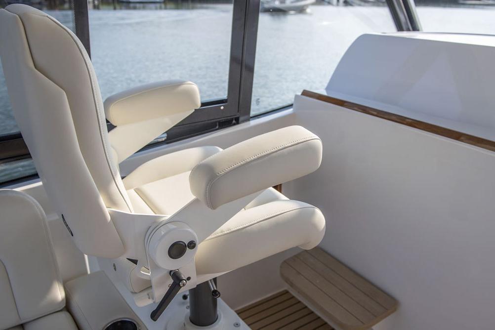 Luxury seating on 2025 MJM 3 boat, featuring white upholstery and armrests.
