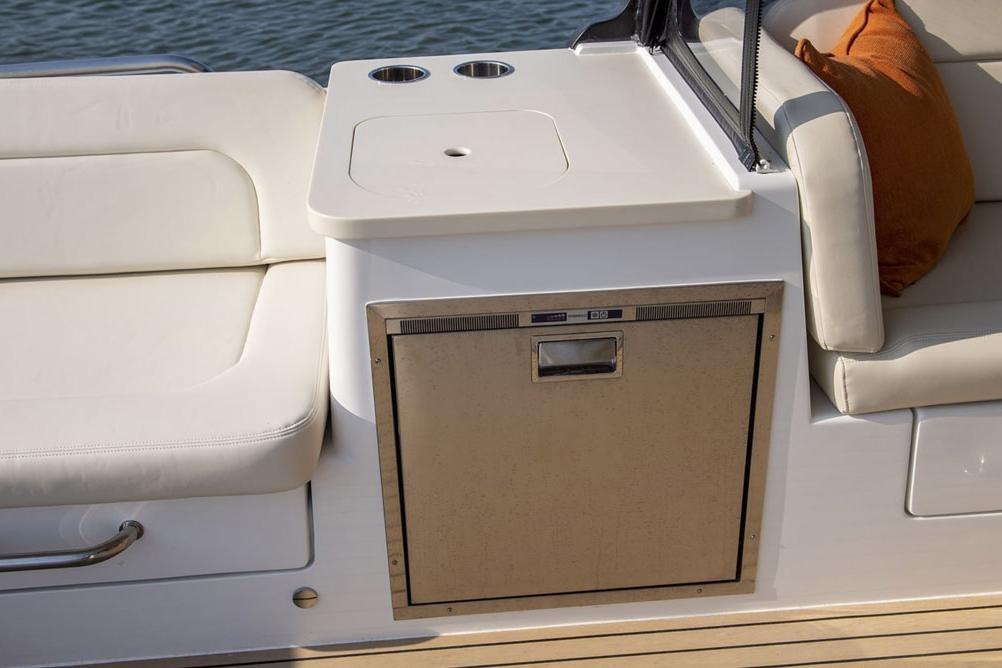 Luxury seating and kitchenette on 2025 MJM 3 boat, featuring sleek design and comfort.