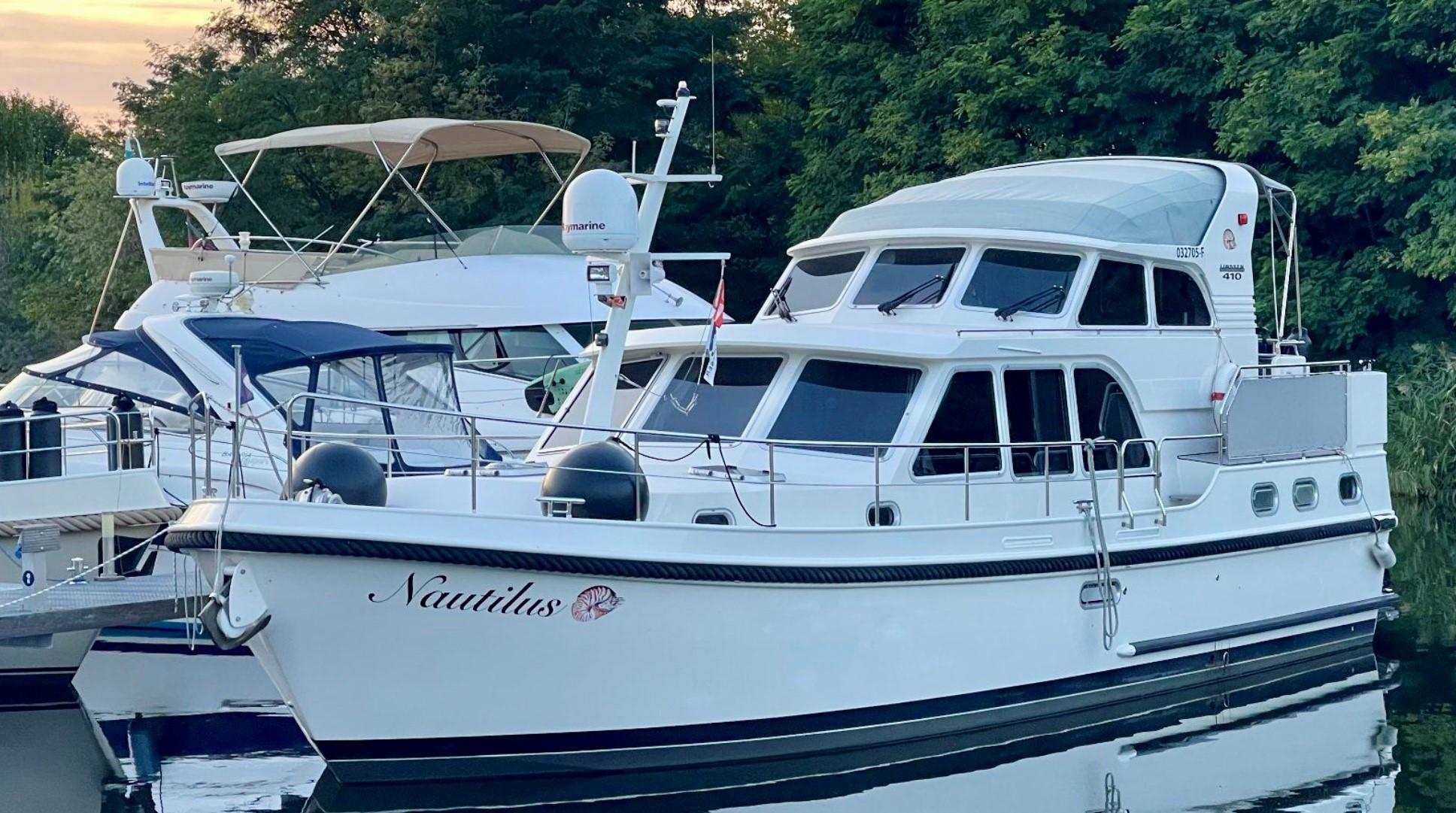 Linssen Grand Sturdy 410 AC Variotop 2016 yacht docked by trees.