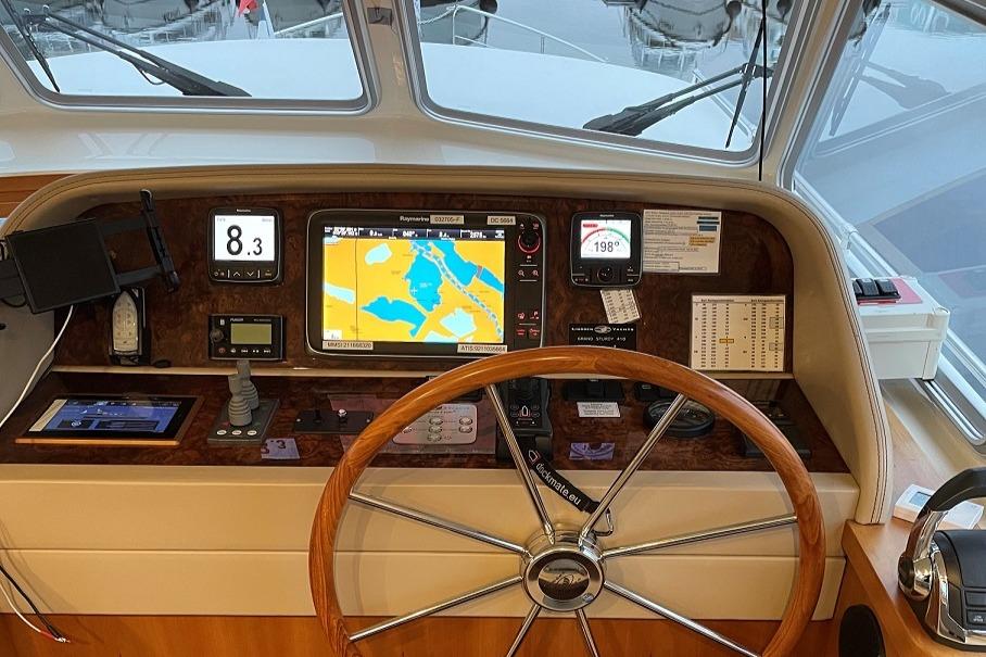 Helm of 2016 Linssen Grand Sturdy 410 AC Variotop with navigation instruments and wooden steering wheel.