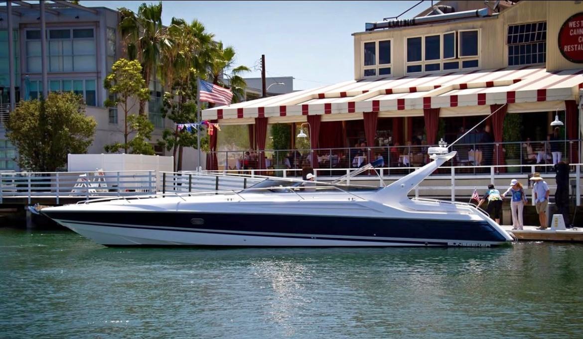 1994 Sunseeker Apache 45 yacht docked near waterfront restaurant.