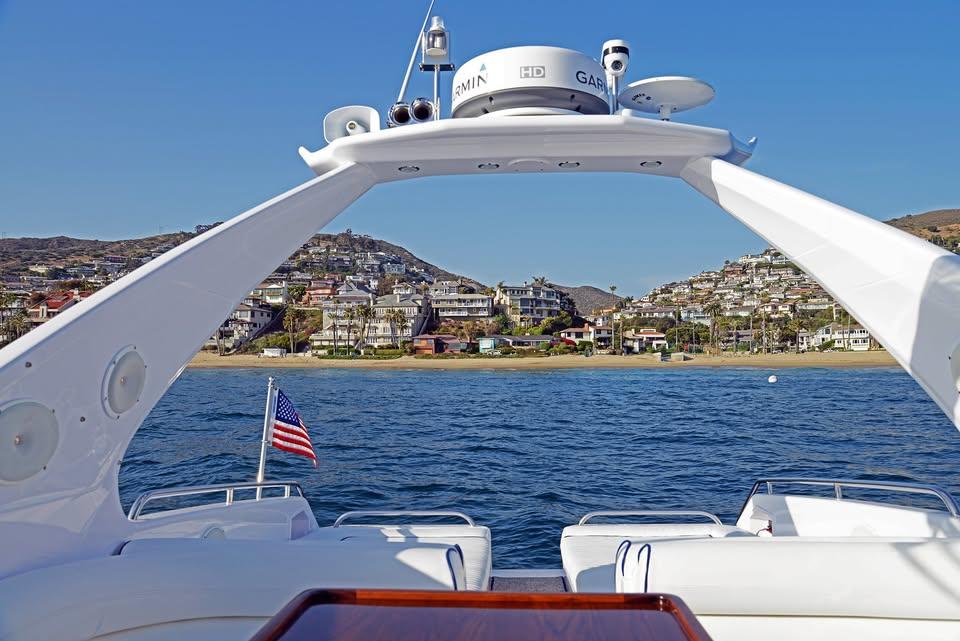 1994 Sunseeker Apache 45 yacht on water, coastal town view, American flag displayed.
