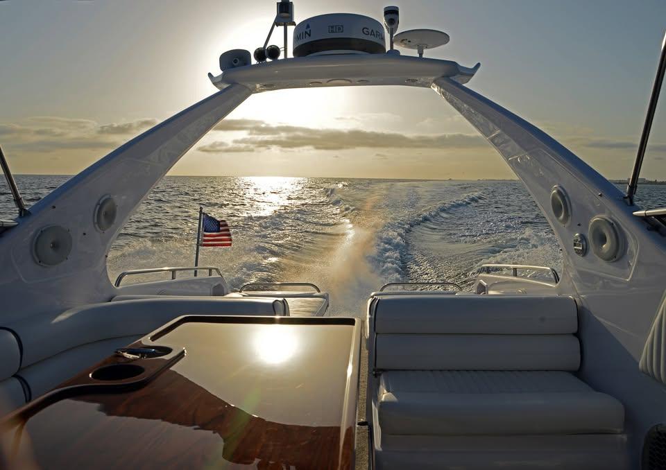 Sunseeker Apache 45 yacht cruising at sunset, 1994 model, with American flag.