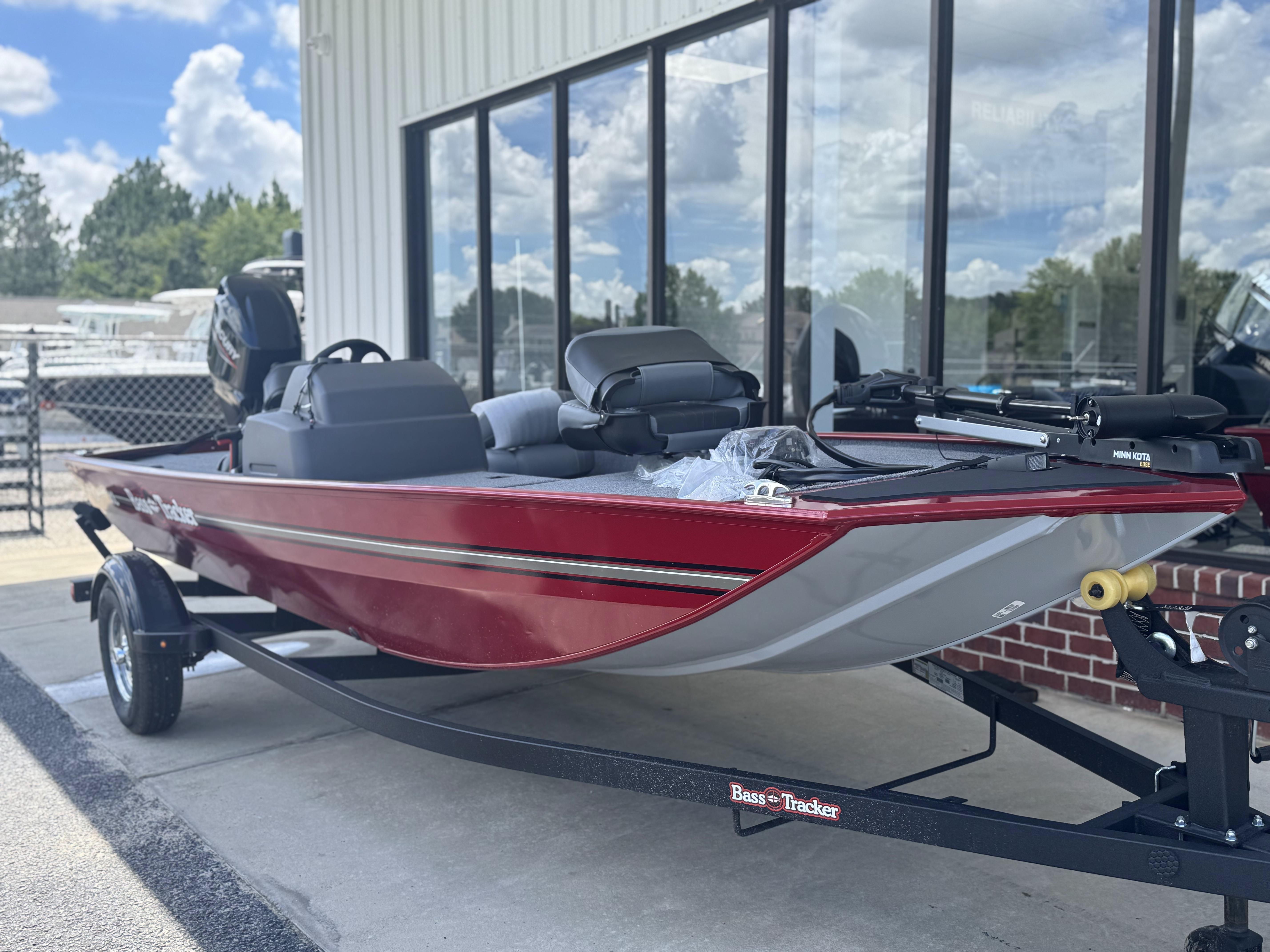 2025 Tracker Bass Tracker Classic XL boat in red, parked on a trailer outside a building.