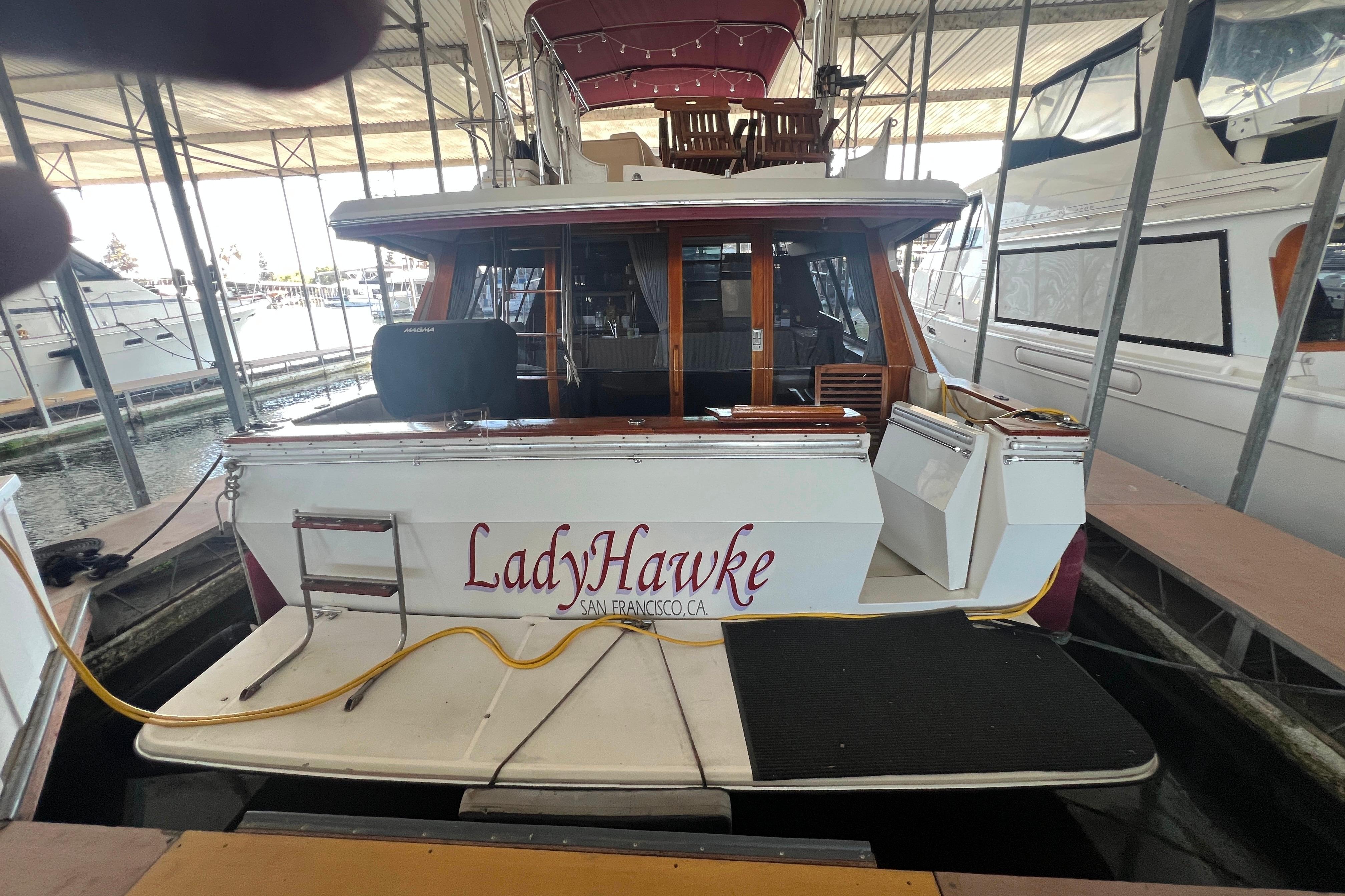 1986 Bayliner 4550 Motoryacht "LadyHawke" docked in marina, rear view.
