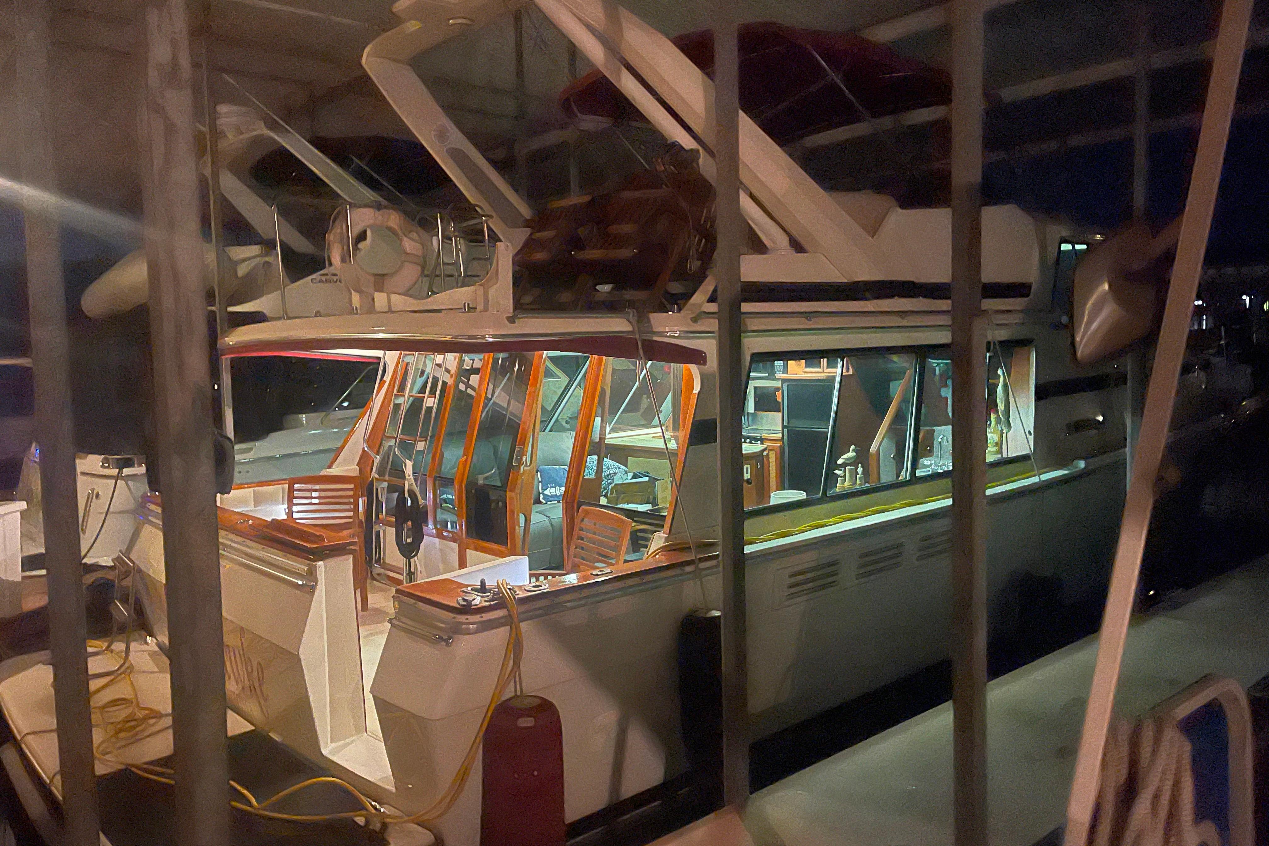 1986 Bayliner 4550 Motoryacht docked at night, illuminated interior visible.