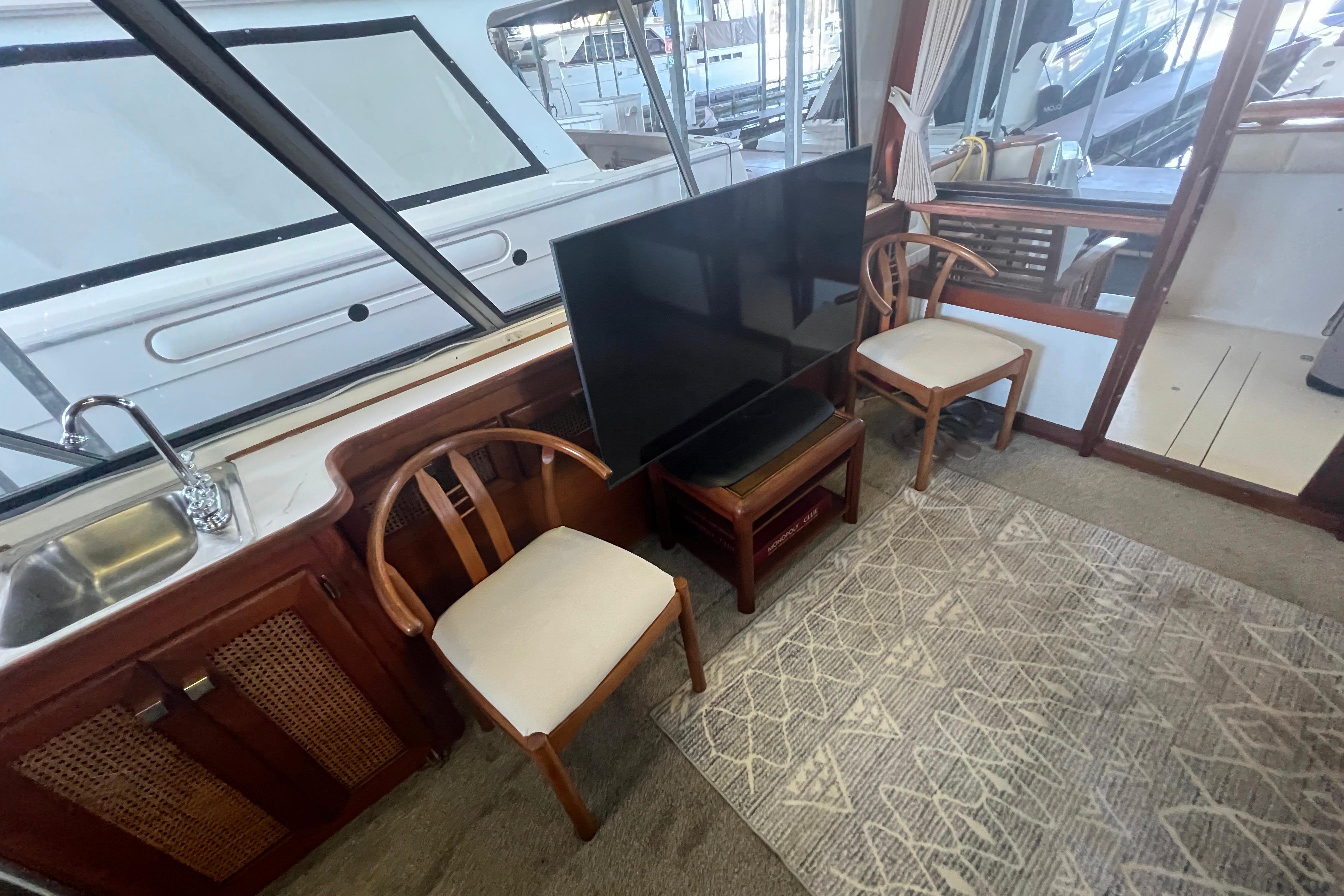 Interior of 1986 Bayliner 4550 Motoryacht with chairs, TV, and sink.
