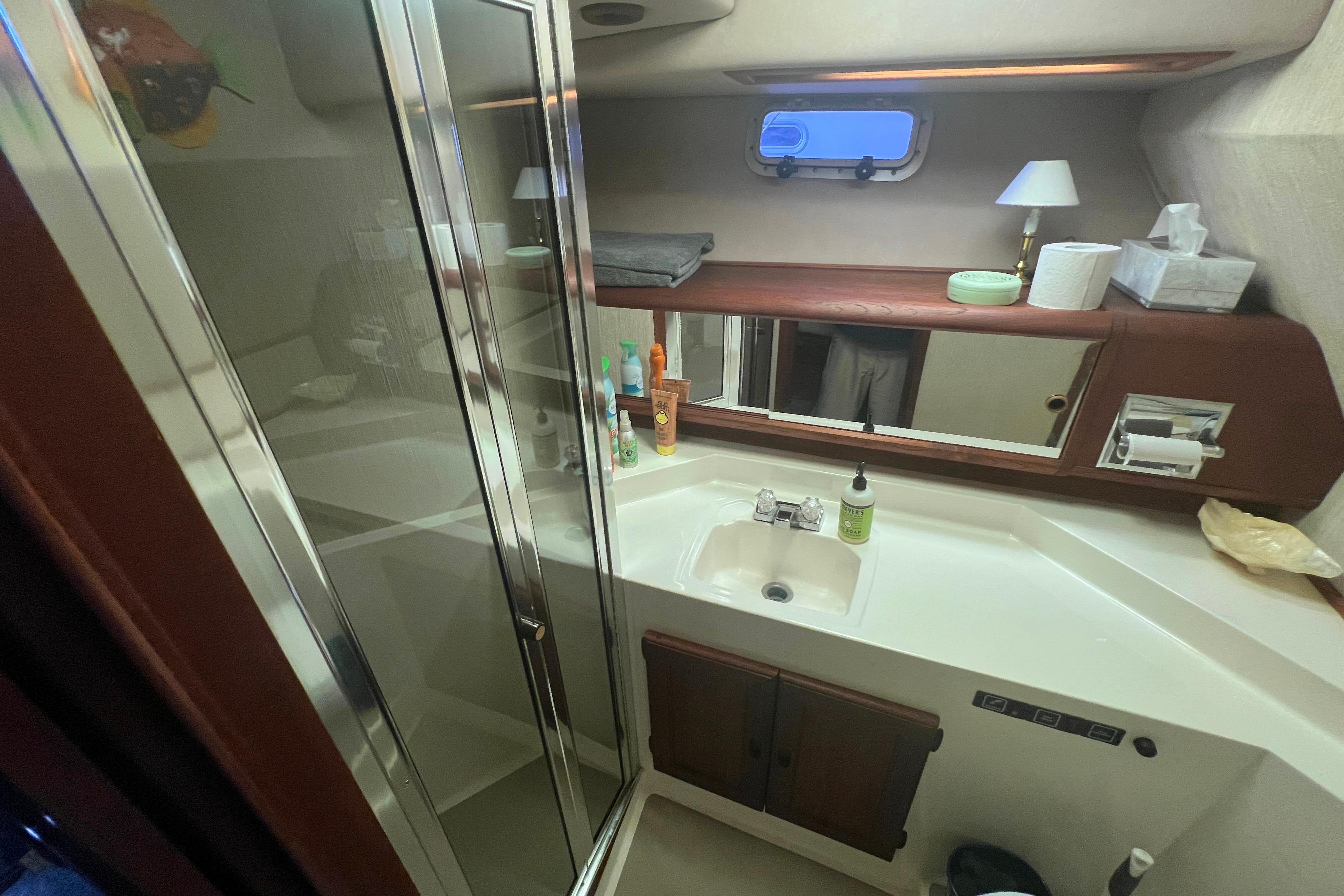Bathroom interior of 1986 Bayliner 4550 Motoryacht with sink, mirror, and toiletries.