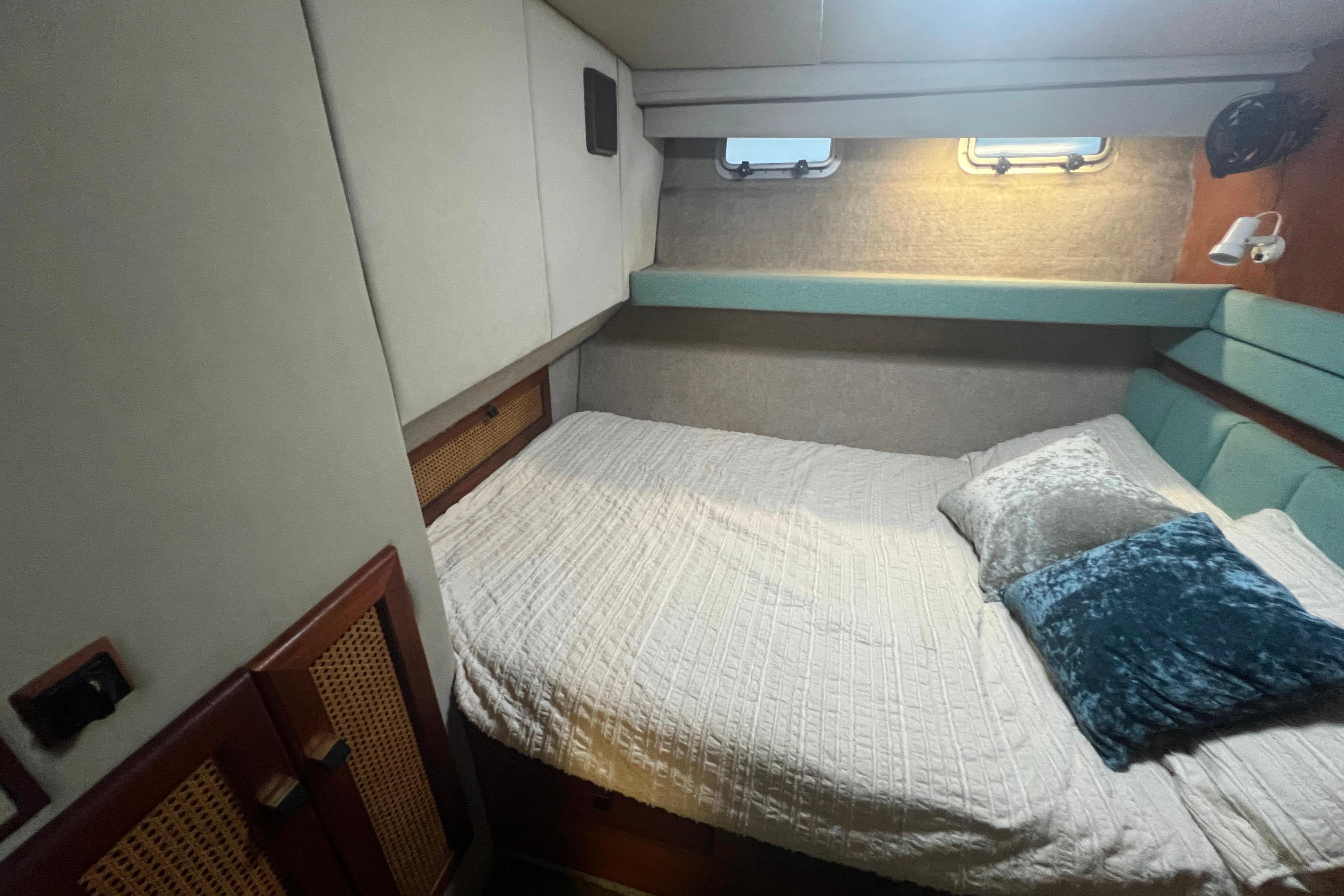Cozy bedroom interior of 1986 Bayliner 4550 Motoryacht with plush bedding and soft lighting.