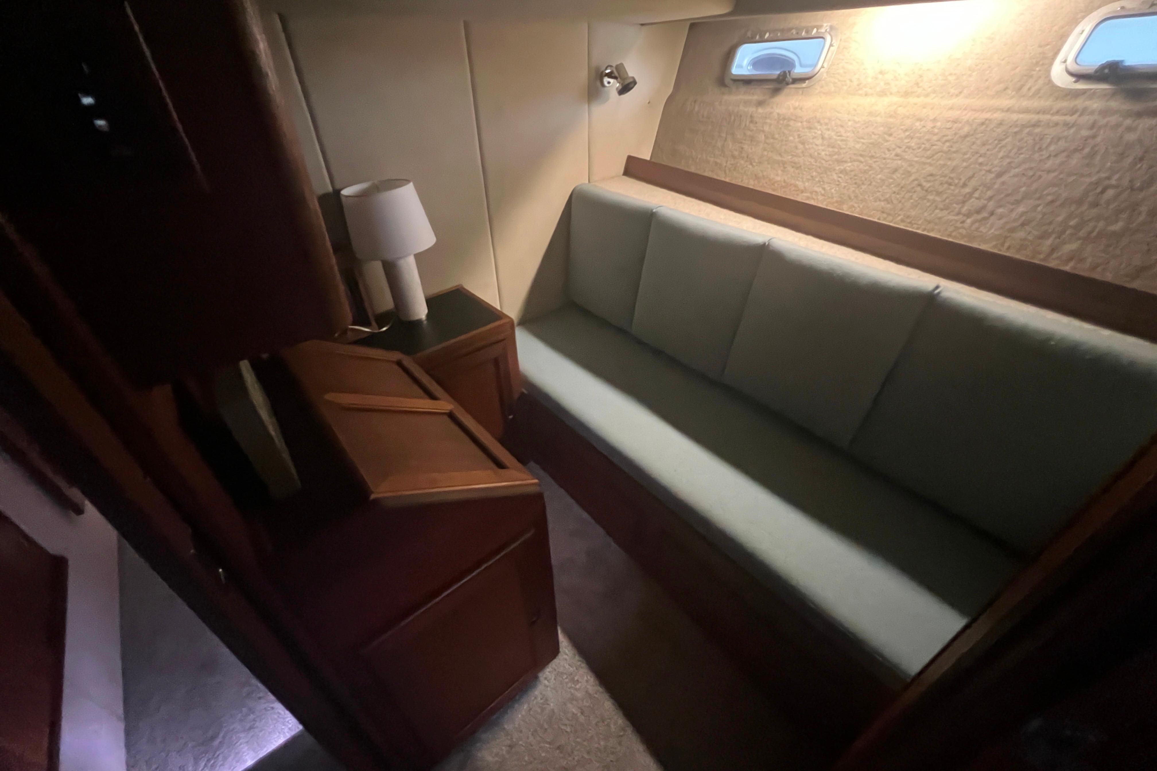 Interior of 1986 Bayliner 4550 Motoryacht with sofa, lamp, and porthole windows.